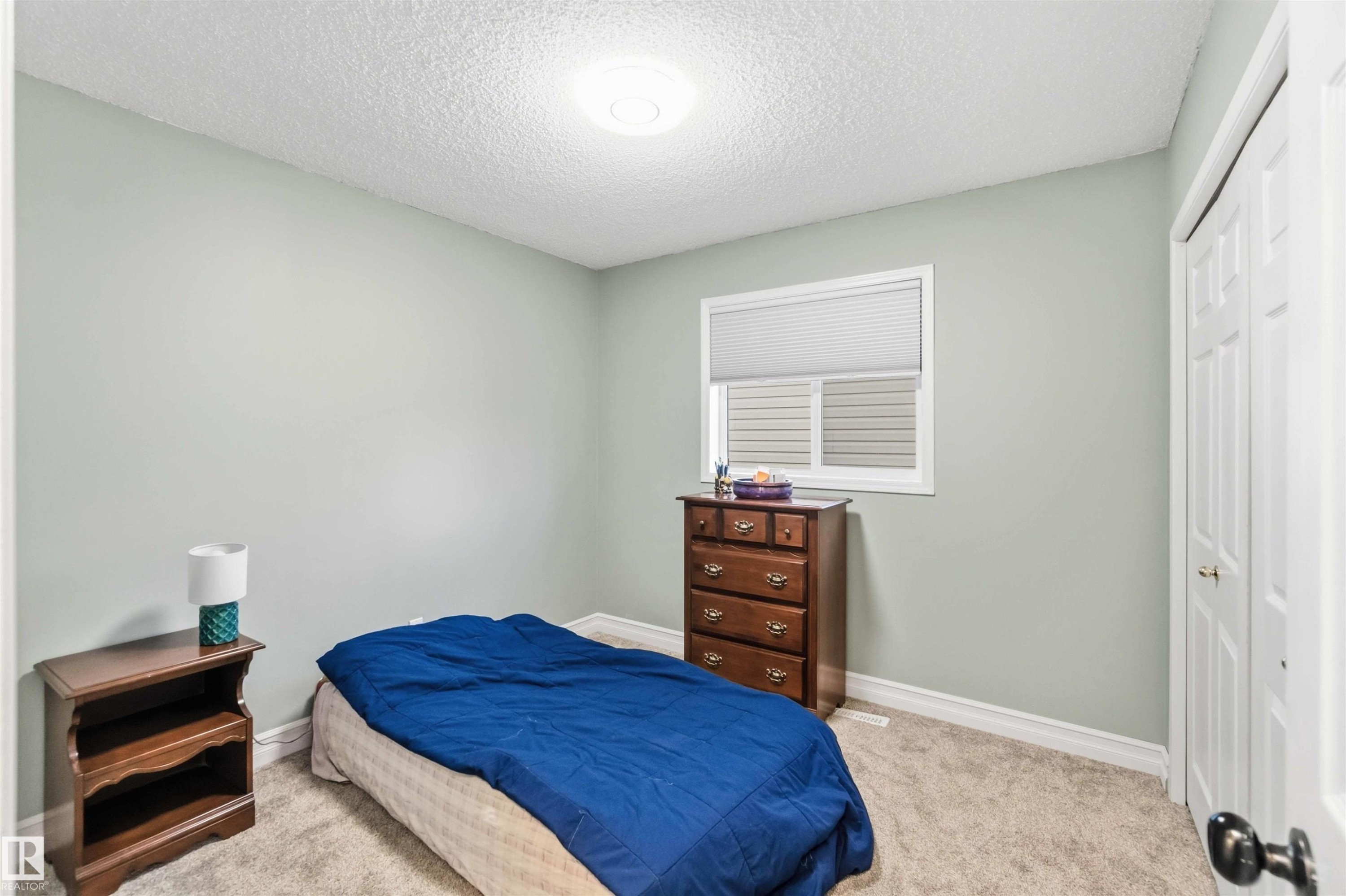 Bedroom with light carpet, a textured ceiling, and a closet - 1706 Turvey Bend, Edmonton, AB - Indoor Photo Showing Bedroom