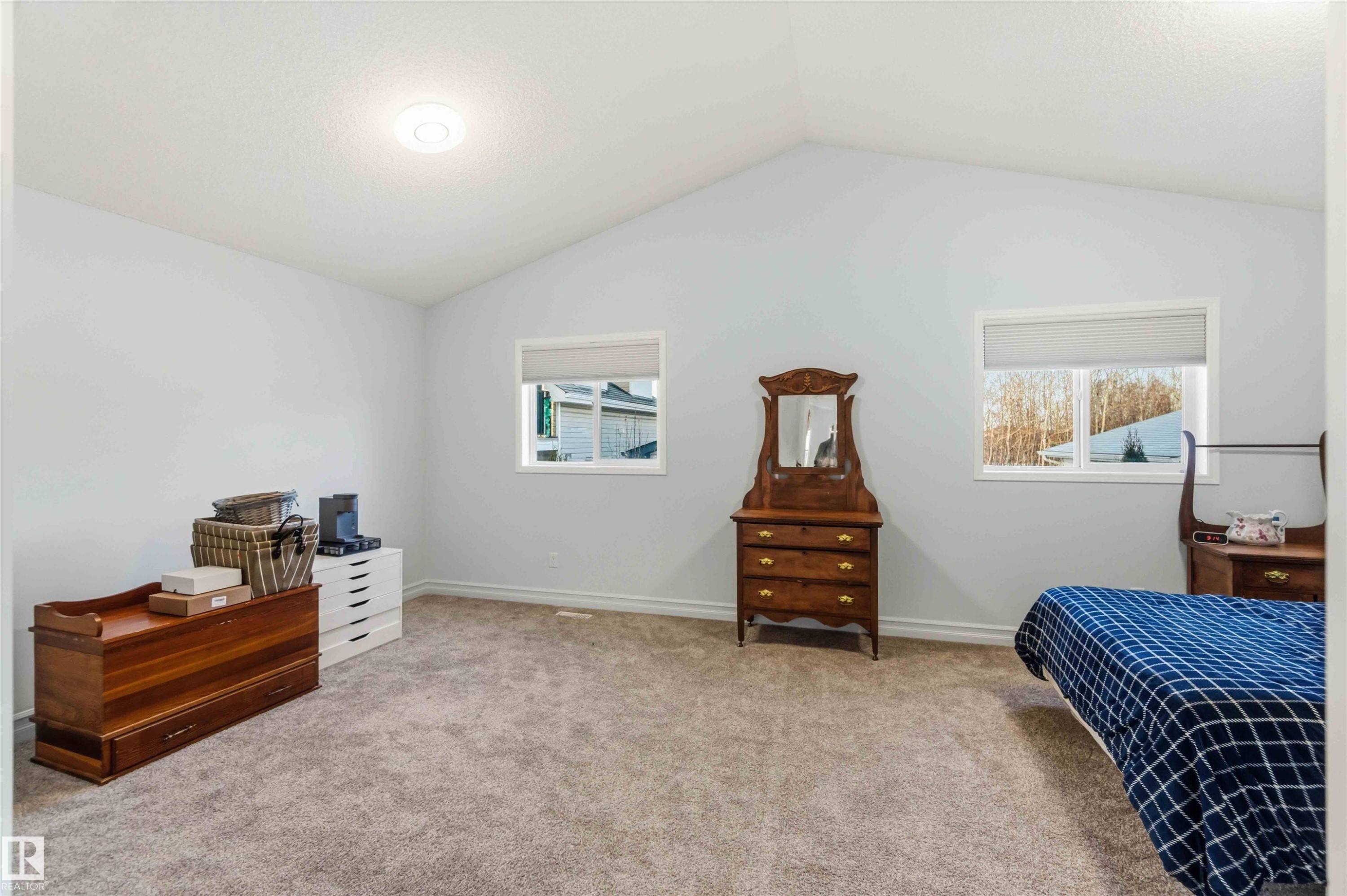 Bedroom with light colored carpet, multiple windows, and a textured ceiling - 1706 Turvey Bend, Edmonton, AB - Indoor Photo Showing Bedroom