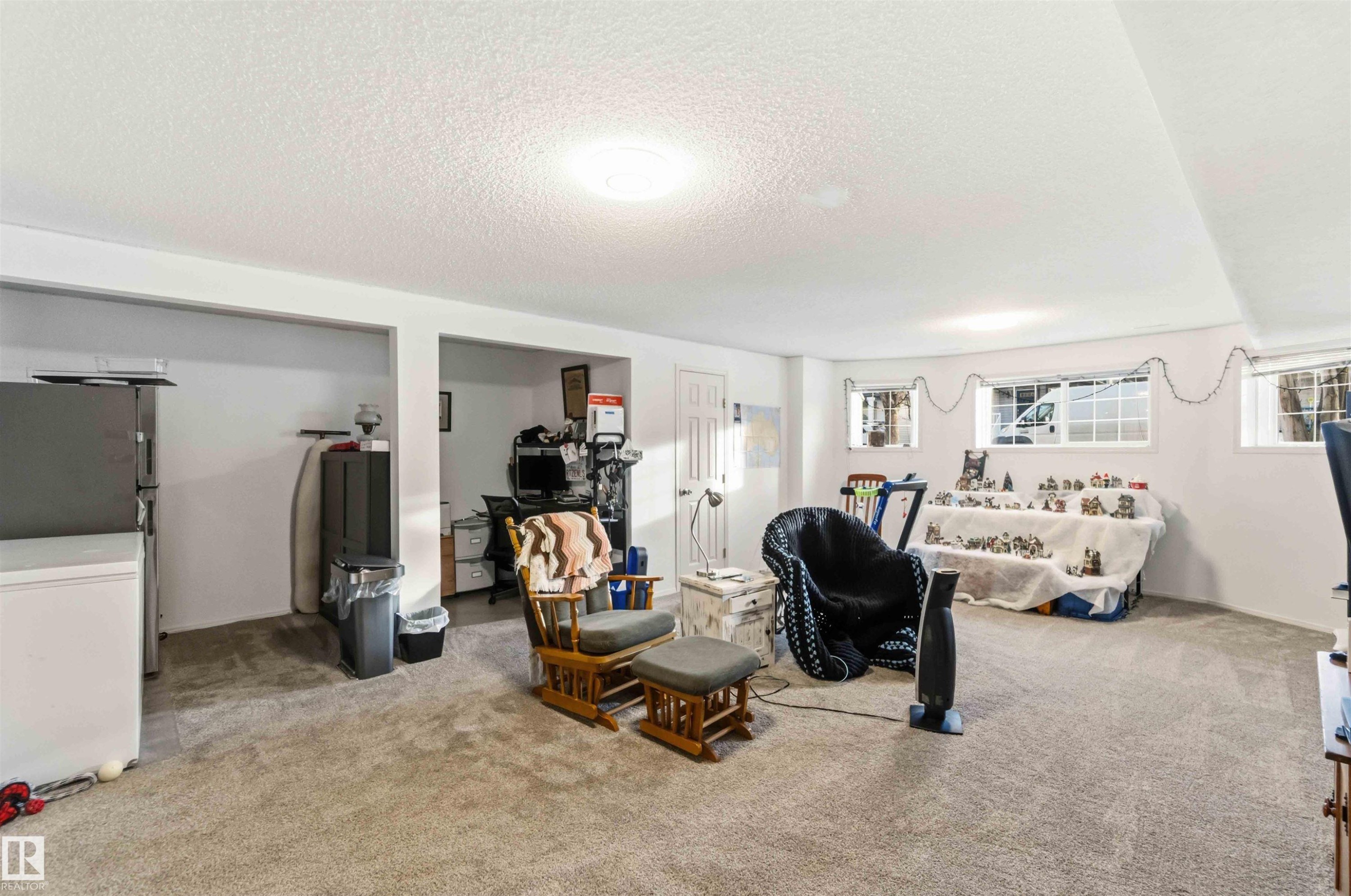 Carpeted living area with healthy amount of natural light and a textured ceiling - 1706 Turvey Bend, Edmonton, AB - Indoor