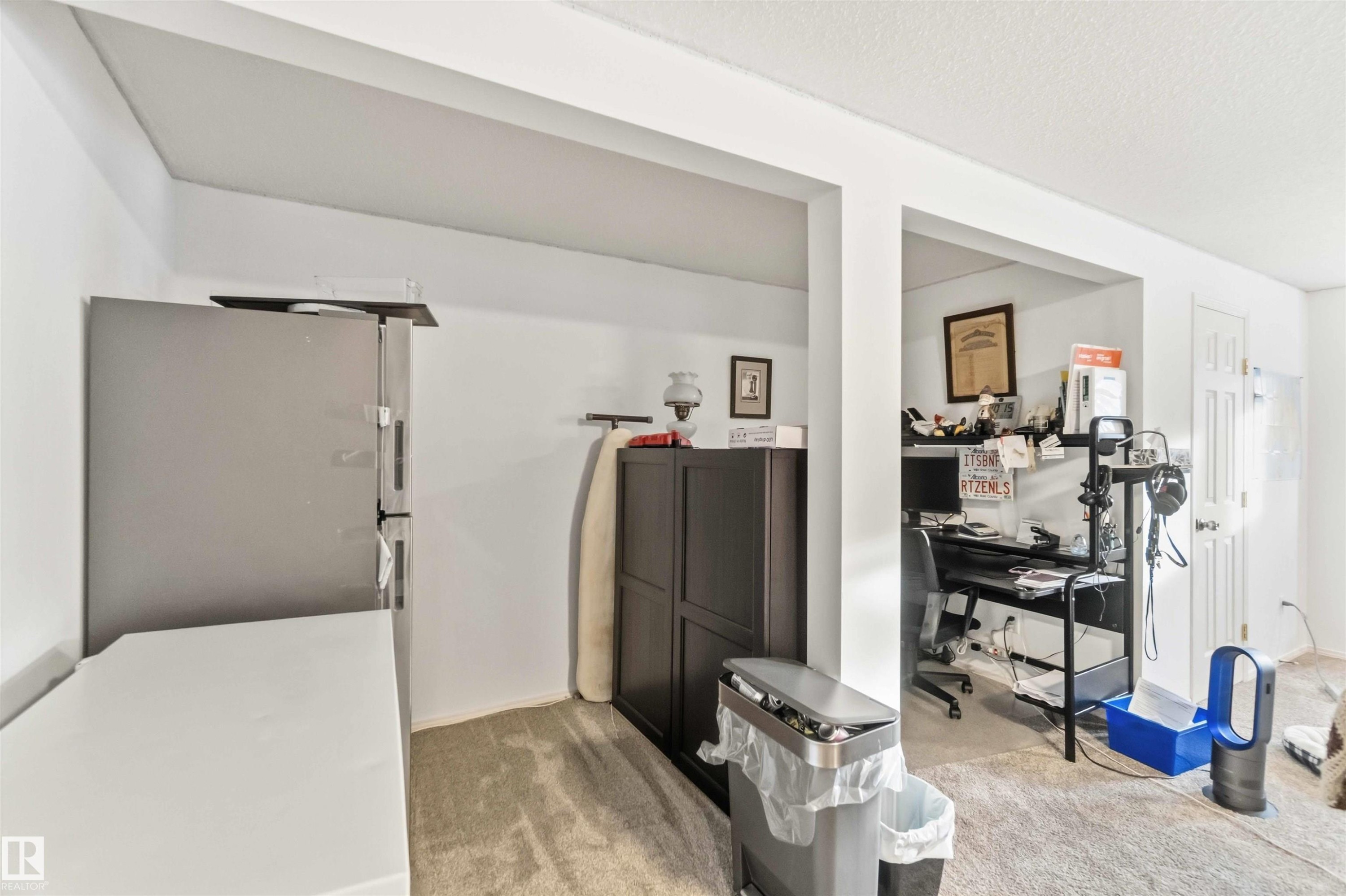 Interior space featuring carpet flooring, freestanding refrigerator, and a textured ceiling - 1706 Turvey Bend, Edmonton, AB - Indoor Photo Showing Other Room