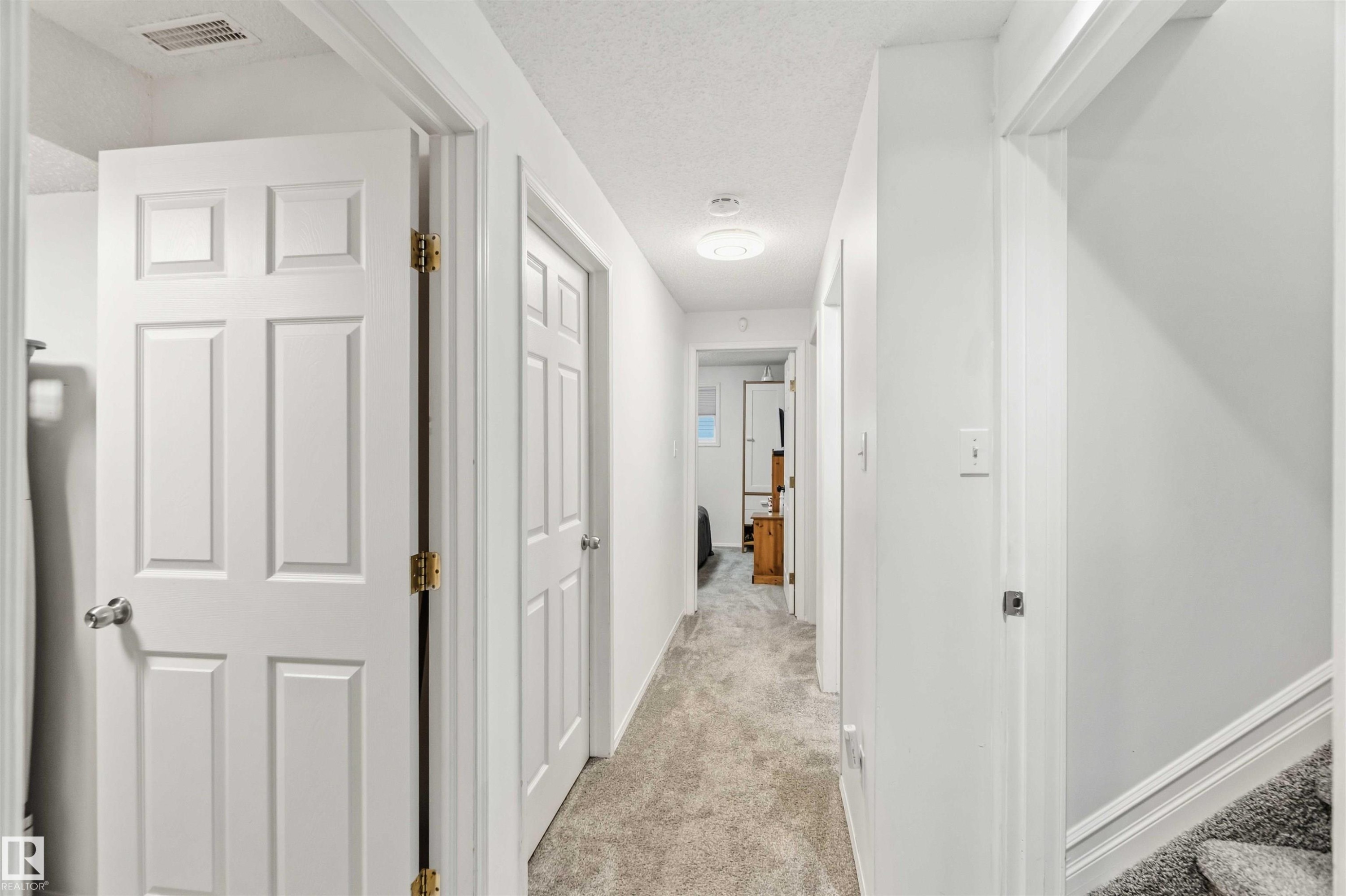 Corridor with light colored carpet and a textured ceiling - 1706 Turvey Bend, Edmonton, AB - Indoor Photo Showing Other Room