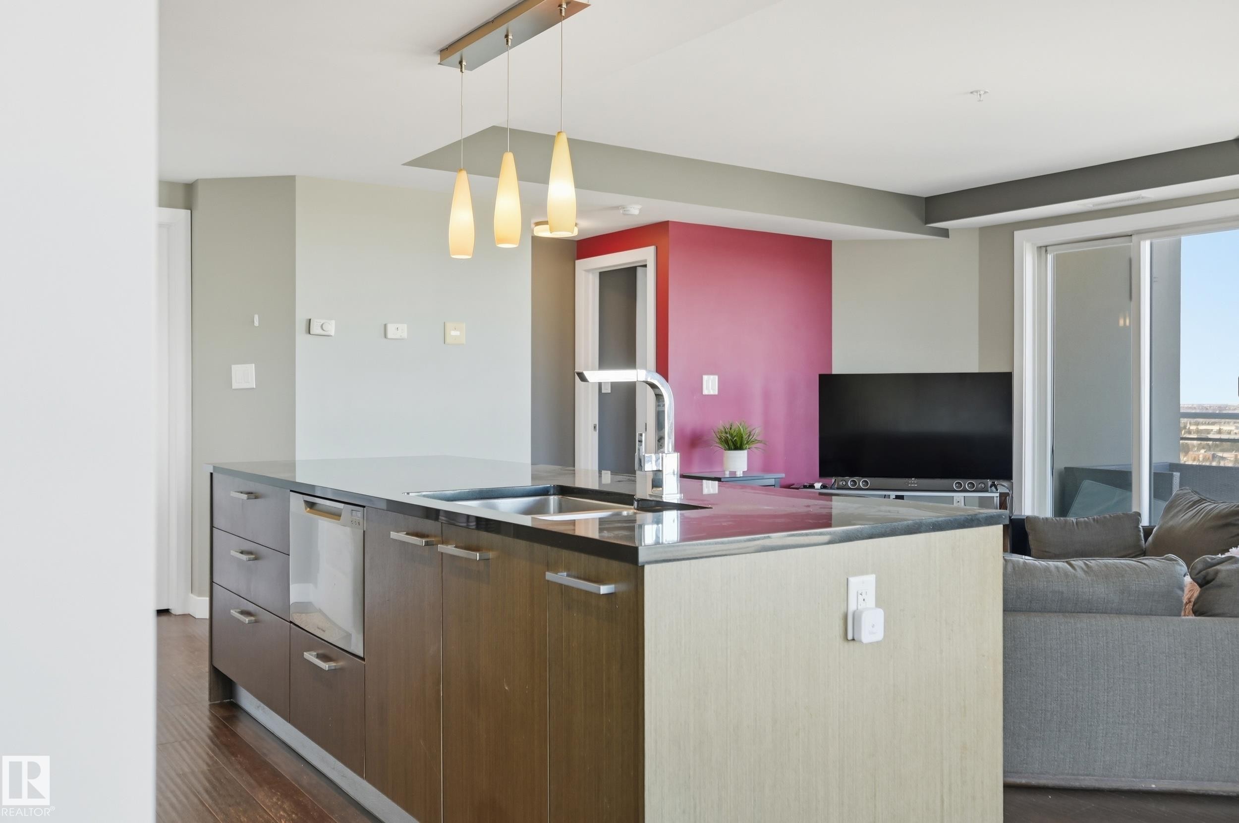 Kitchen with modern cabinets, pendant lighting, open floor plan, dark wood-style flooring, and an island with sink - 2003 10388 105 Street, Edmonton, AB - Indoor Photo Showing Kitchen With Upgraded Kitchen