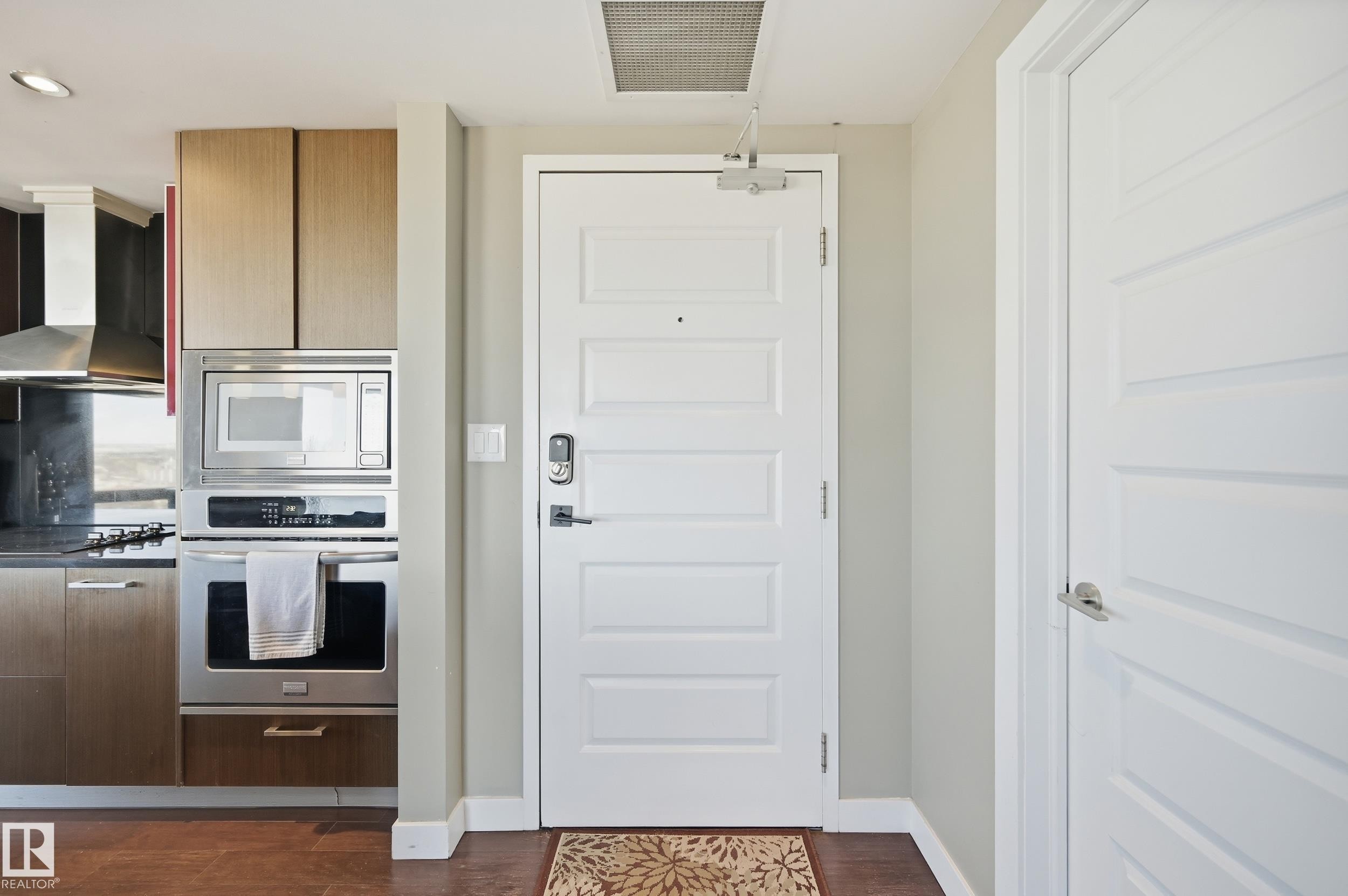 Kitchen featuring stainless steel appliances, dark wood-type flooring, and modern cabinets - 2003 10388 105 Street, Edmonton, AB - Indoor