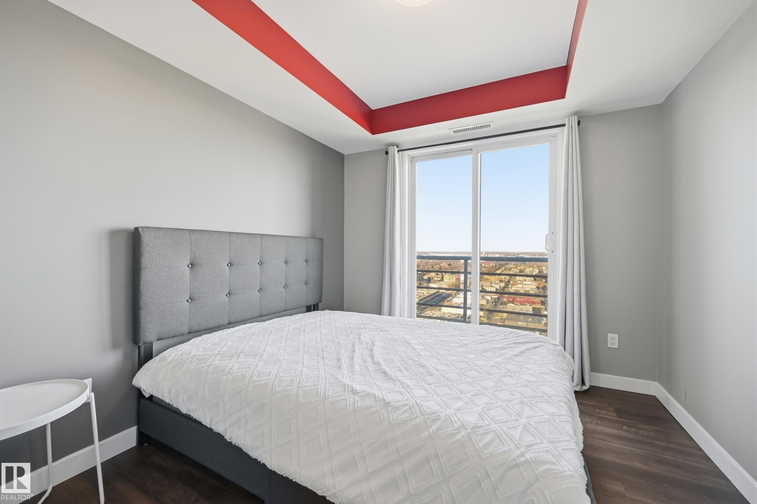 Bedroom featuring a tray ceiling and dark wood-style floors - 2003 10388 105 Street, Edmonton, AB - Indoor Photo Showing Bedroom
