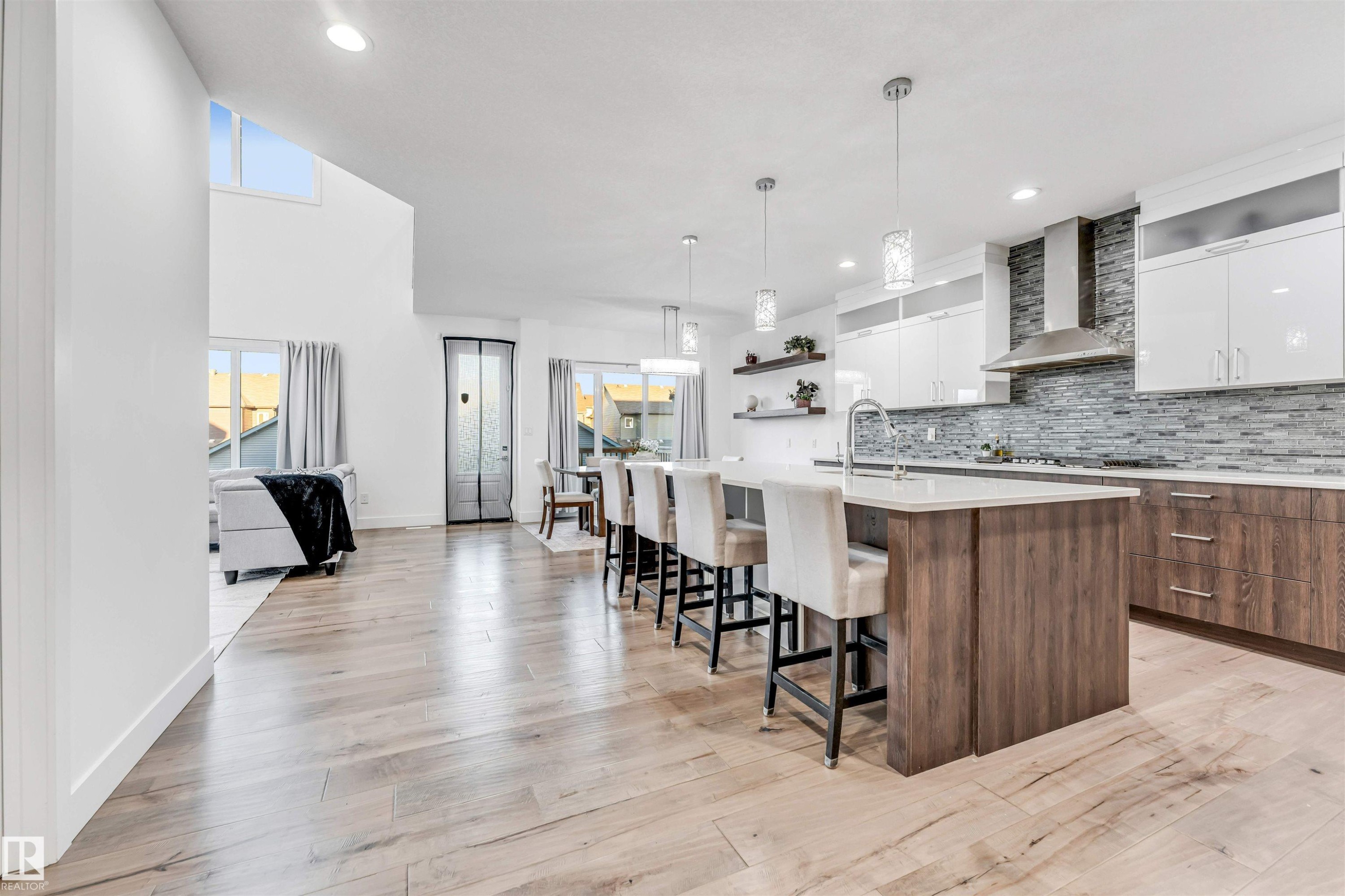 Kitchen featuring dual tone cabinets, modern cabinets, open shelves, a kitchen bar, and a center island with sink - 1407 Graydon Hill Way, Edmonton, AB - Indoor Photo Showing Other Room