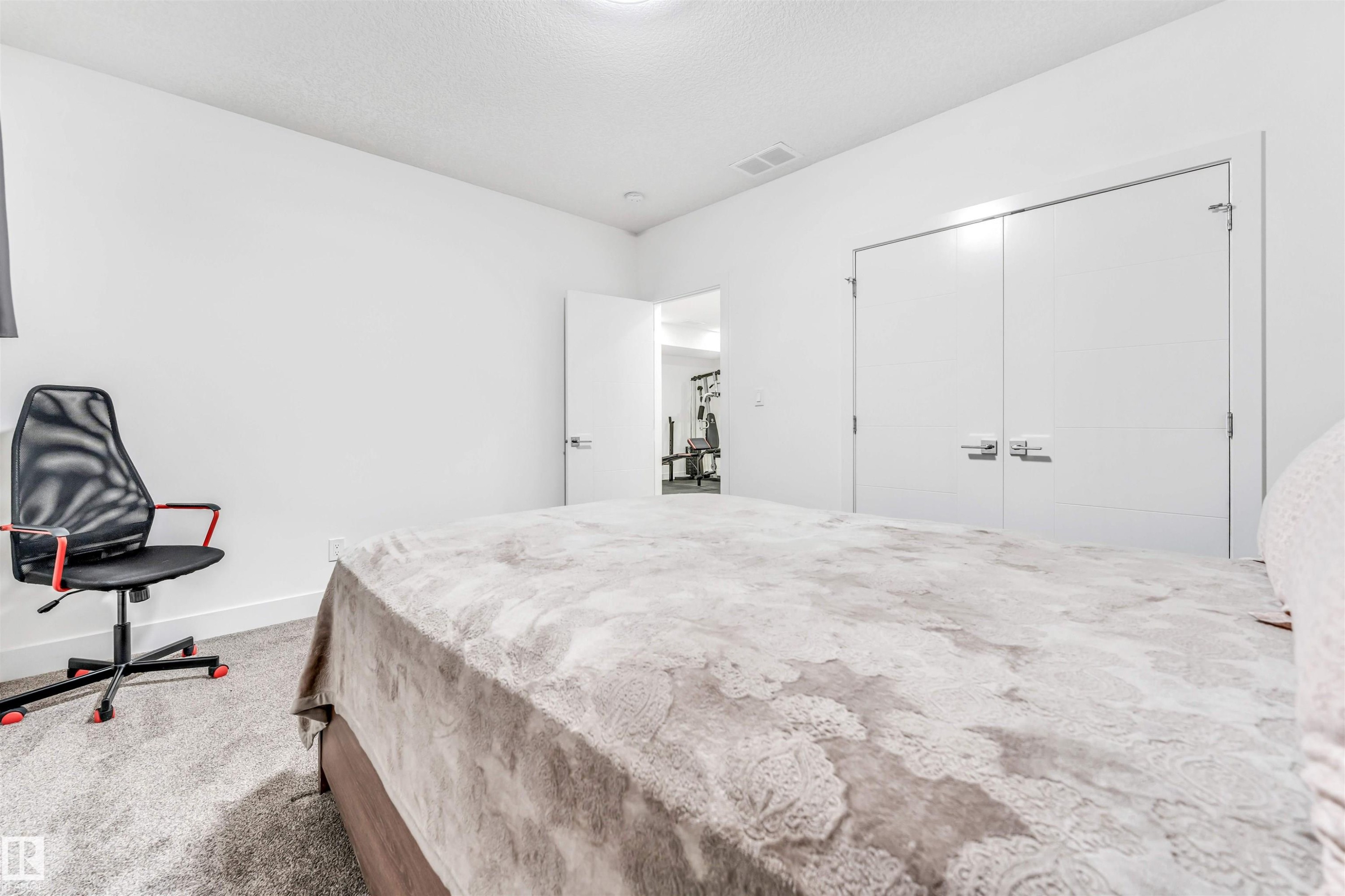 Carpeted bedroom with a closet and a textured ceiling - 1407 Graydon Hill Way, Edmonton, AB - Indoor Photo Showing Bedroom