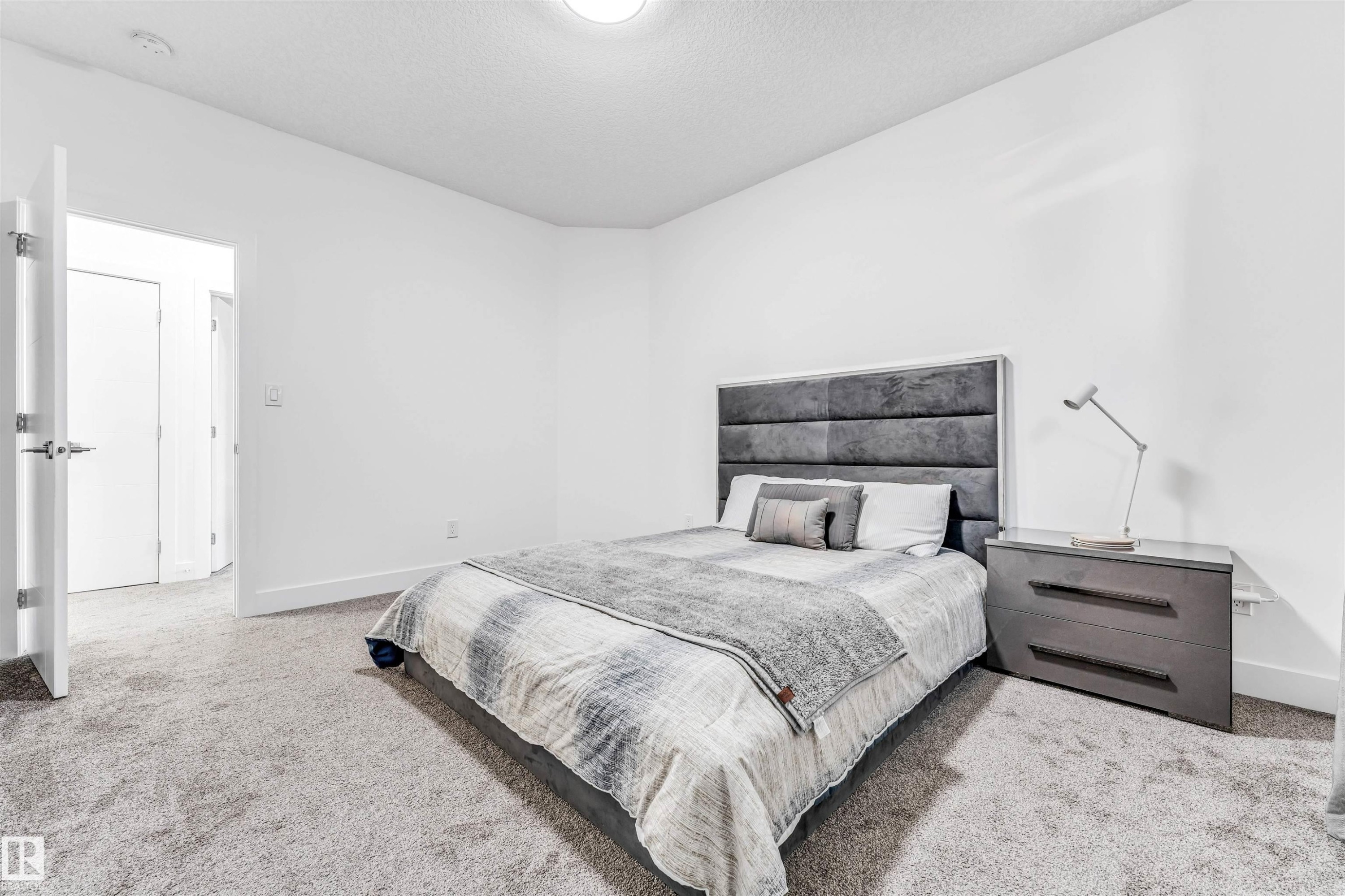 Carpeted bedroom featuring baseboards and a textured ceiling - 1407 Graydon Hill Way, Edmonton, AB - Indoor Photo Showing Bedroom