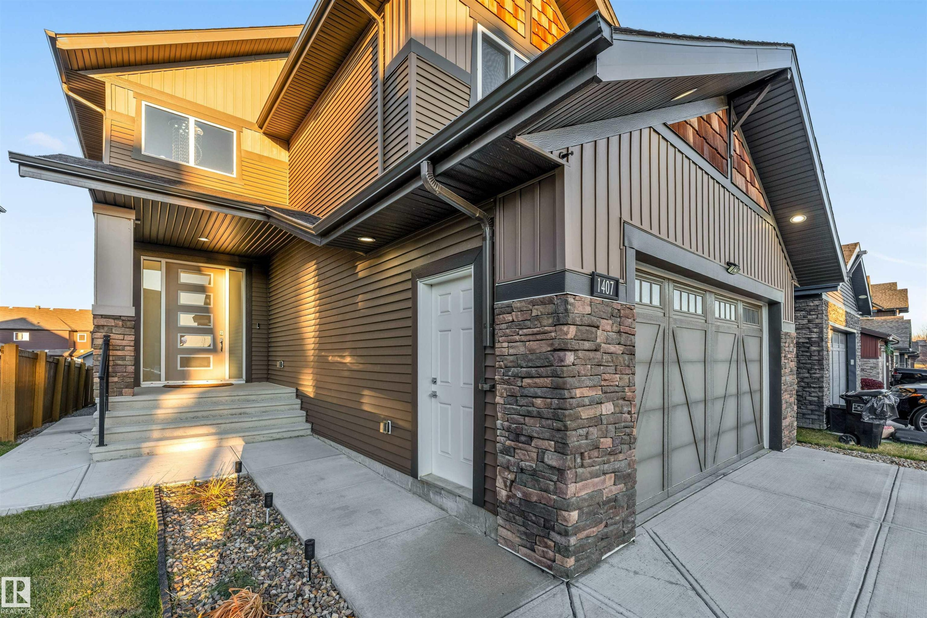 Property entrance with stone siding, board and batten siding, and driveway - 1407 Graydon Hill Way, Edmonton, AB - Outdoor With Exterior