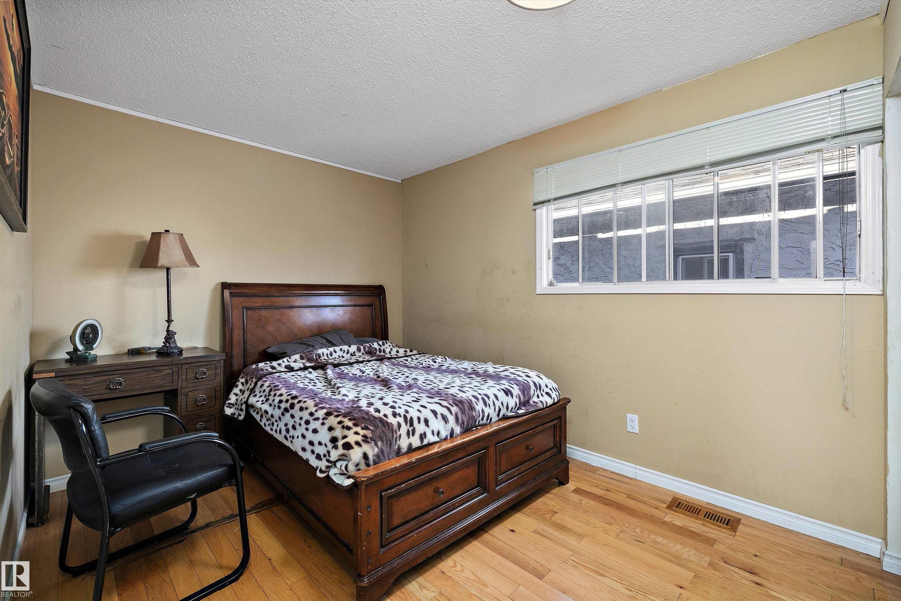 Bedroom featuring light wood-style floors and a textured ceiling - 12117 91 Street, Edmonton, AB - Indoor Photo Showing Bedroom