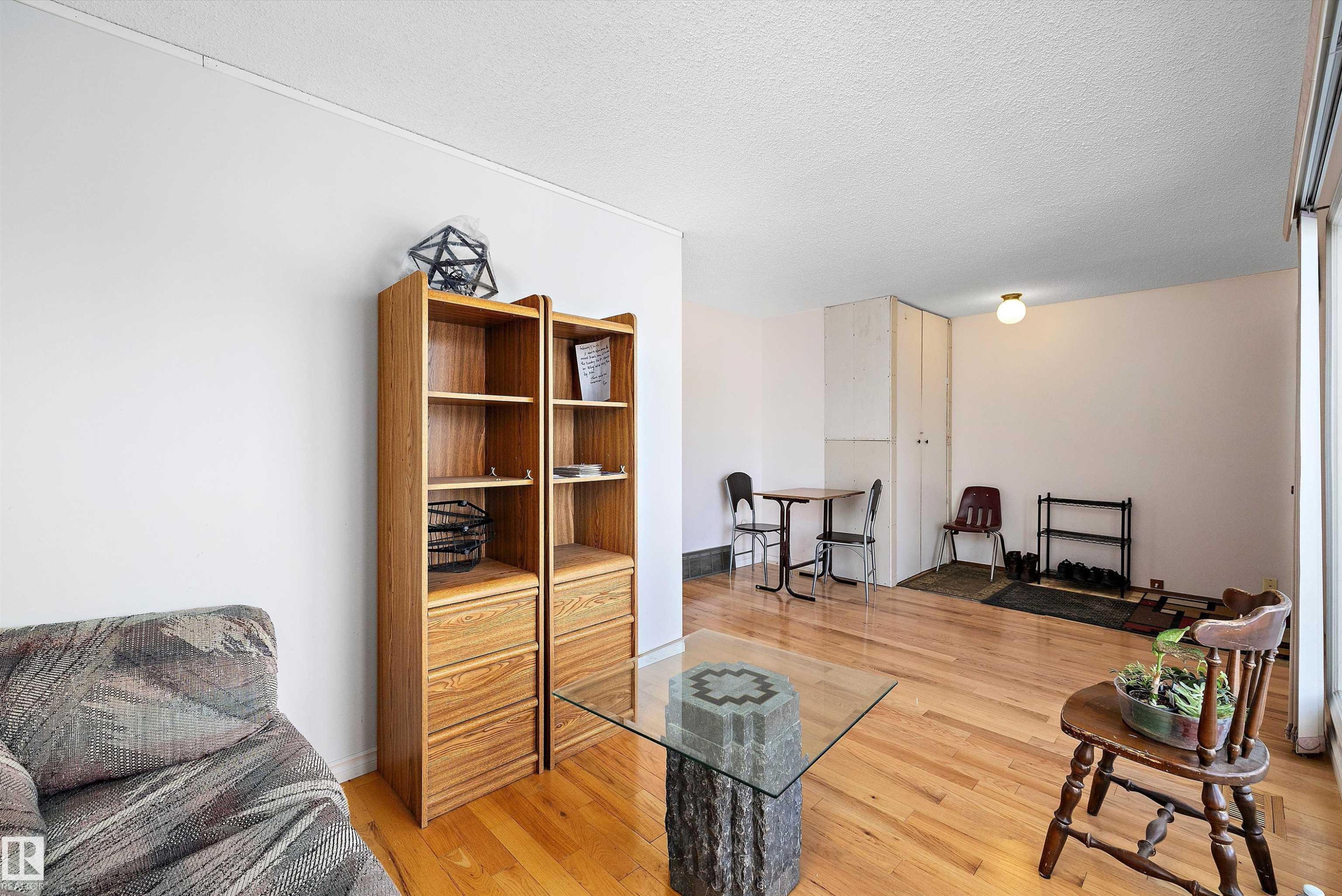 Living area with a textured ceiling and light wood-style flooring - 12117 91 Street, Edmonton, AB - Indoor