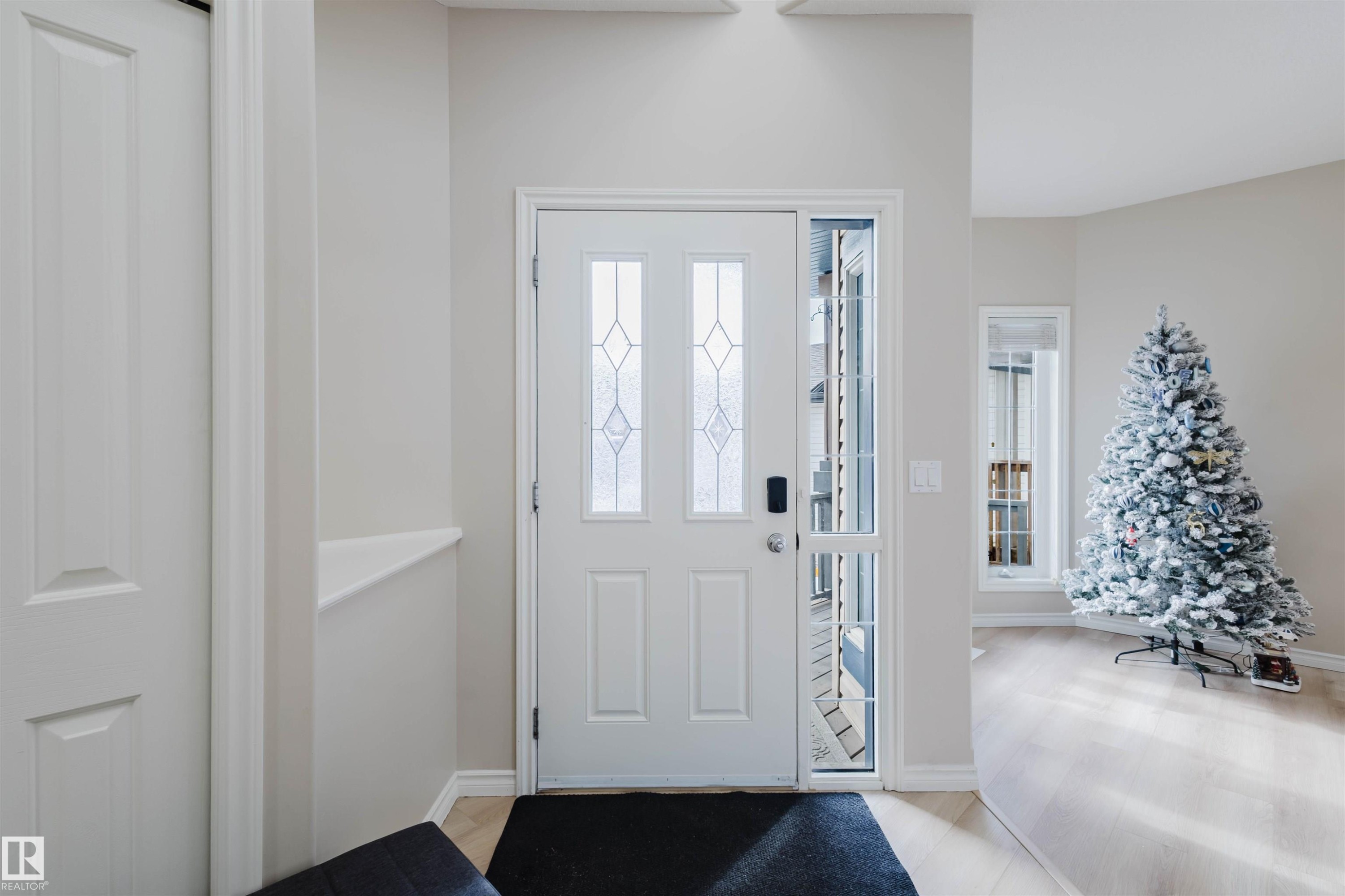 Entrance foyer with light wood-type flooring and baseboards - 8420 Sloane Crescent, Edmonton, AB - Indoor Photo Showing Other Room