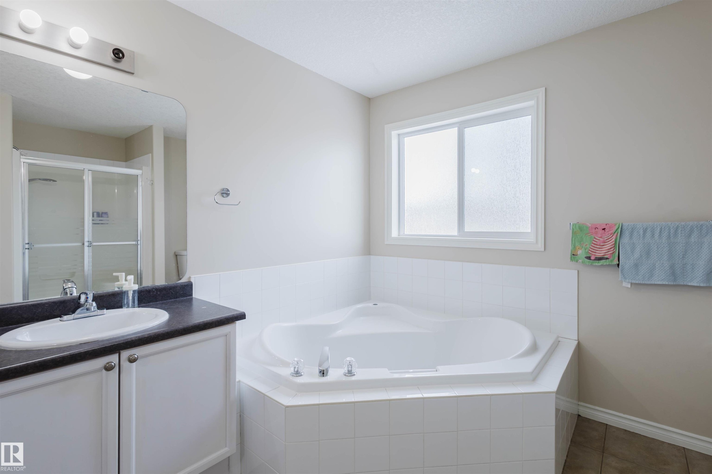 Bathroom with a garden tub, a stall shower, vanity, and tile patterned flooring - 8420 Sloane Crescent, Edmonton, AB - Indoor Photo Showing Bathroom