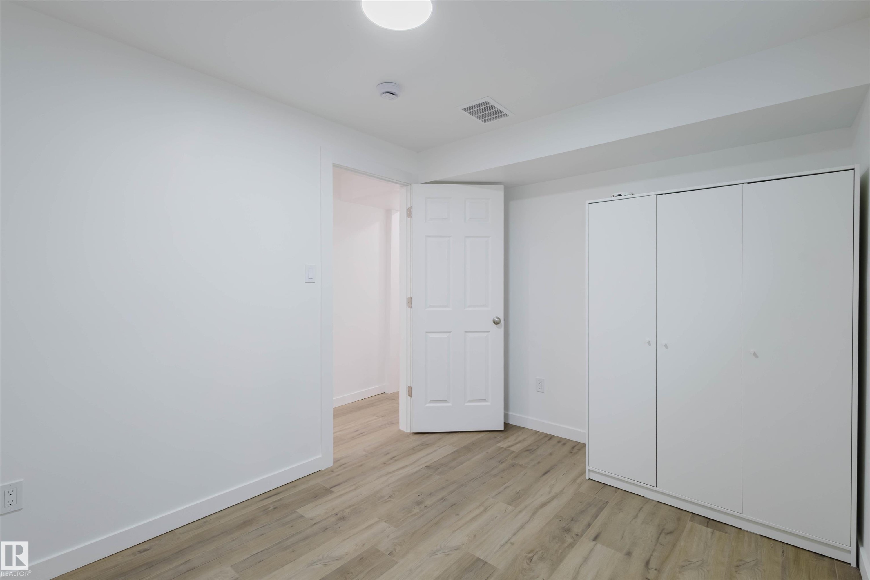 Unfurnished bedroom featuring light wood-type flooring and a closet - 8420 Sloane Crescent, Edmonton, AB - Indoor Photo Showing Other Room