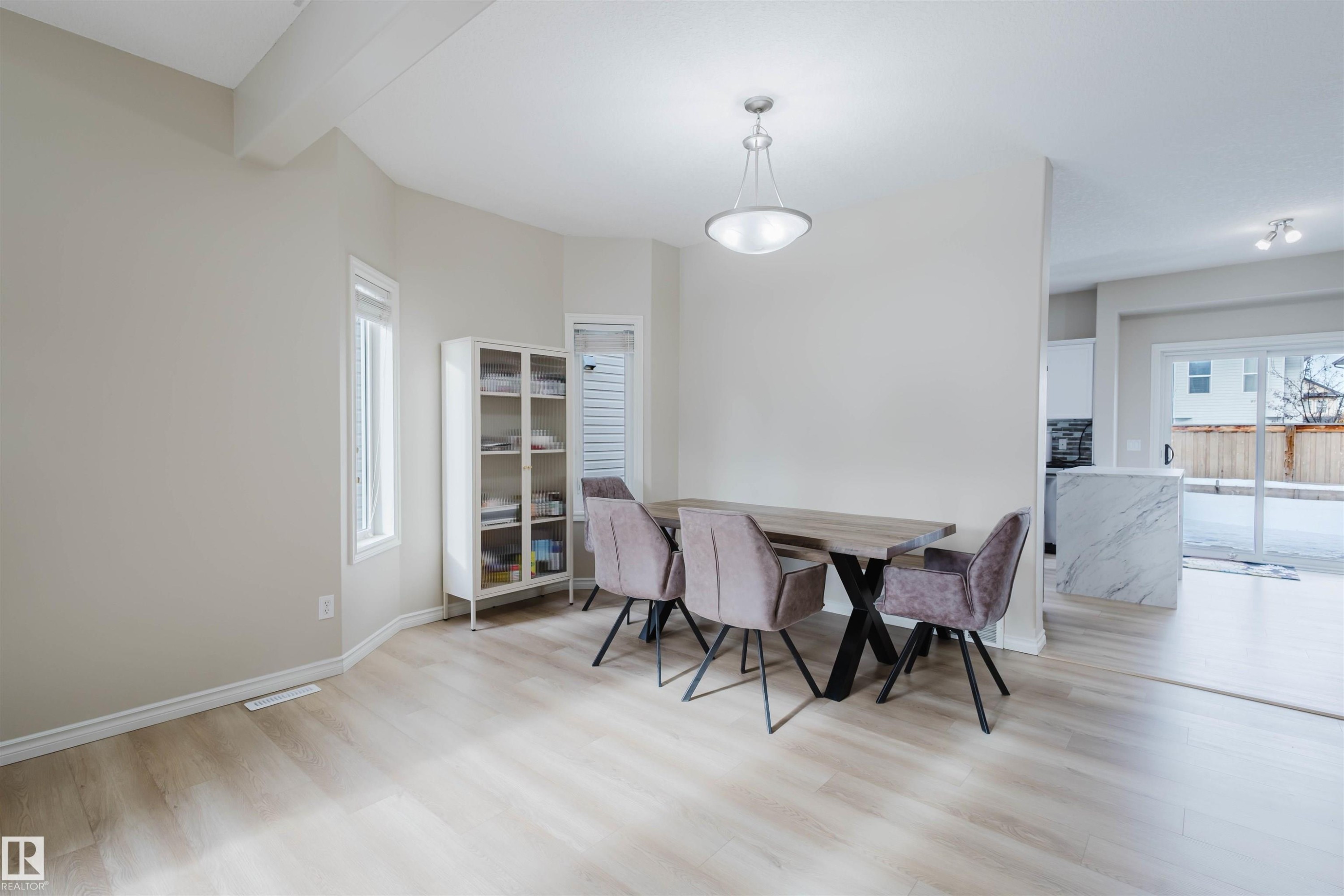 Dining area featuring light wood finished floors and beamed ceiling - 8420 Sloane Crescent, Edmonton, AB - Indoor Photo Showing Dining Room