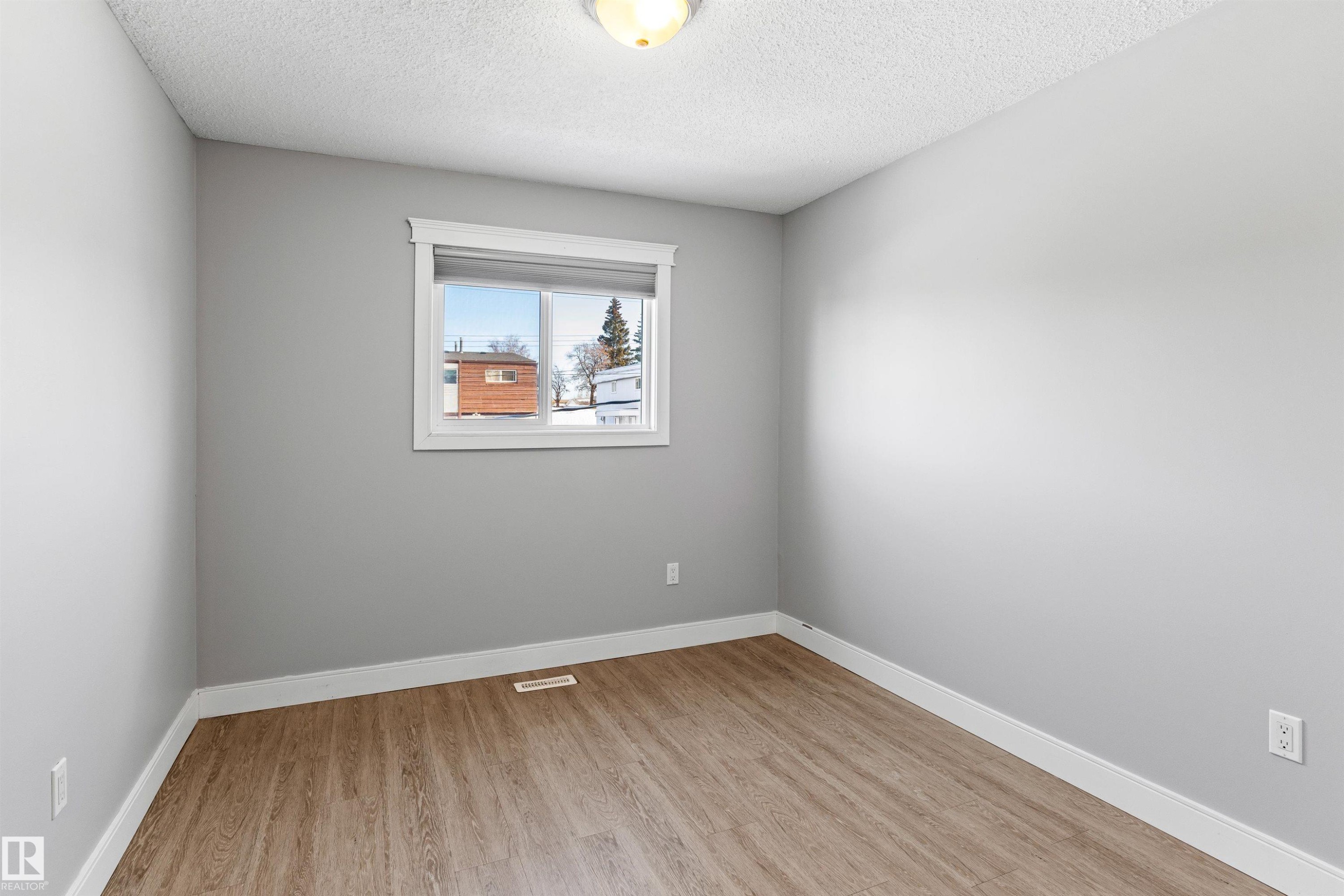 Empty room featuring light wood finished floors and a textured ceiling - 914 9 Street, Cold Lake, AB - Indoor Photo Showing Other Room