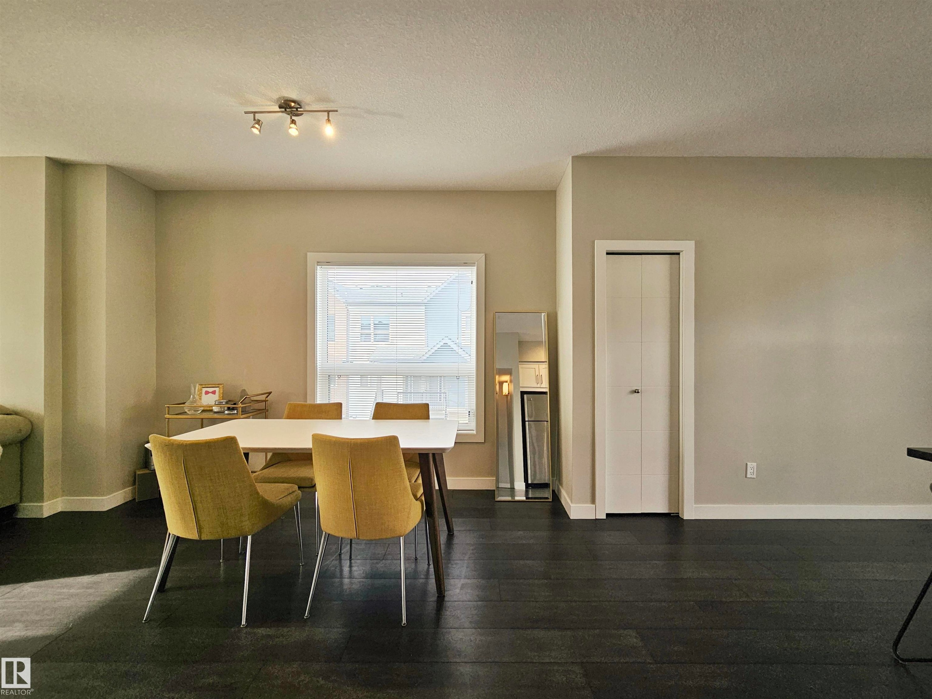 Dining room featuring dark wood-style floors and a textured ceiling - 129 2560 Pegasus Boulevard, Edmonton, AB - Indoor Photo Showing Dining Room