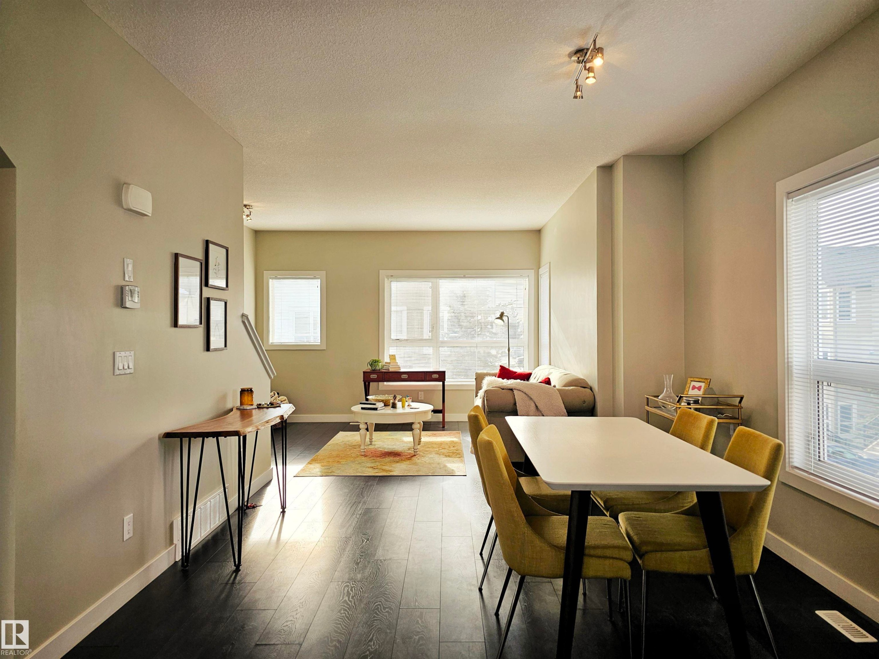 Dining room featuring dark wood finished floors and a textured ceiling - 129 2560 Pegasus Boulevard, Edmonton, AB - Indoor