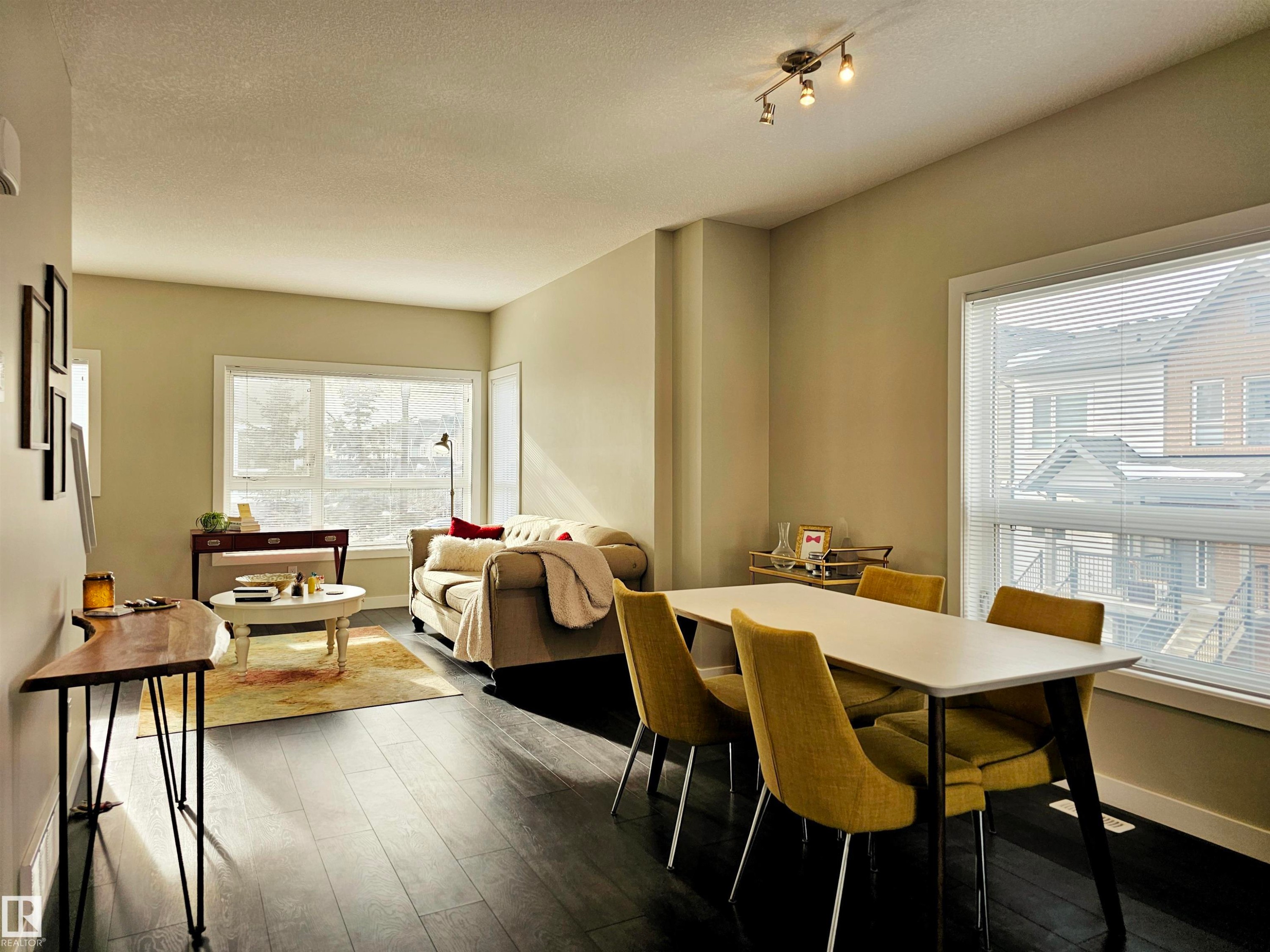 Dining room featuring dark wood-style flooring and a textured ceiling - 129 2560 Pegasus Boulevard, Edmonton, AB - Indoor