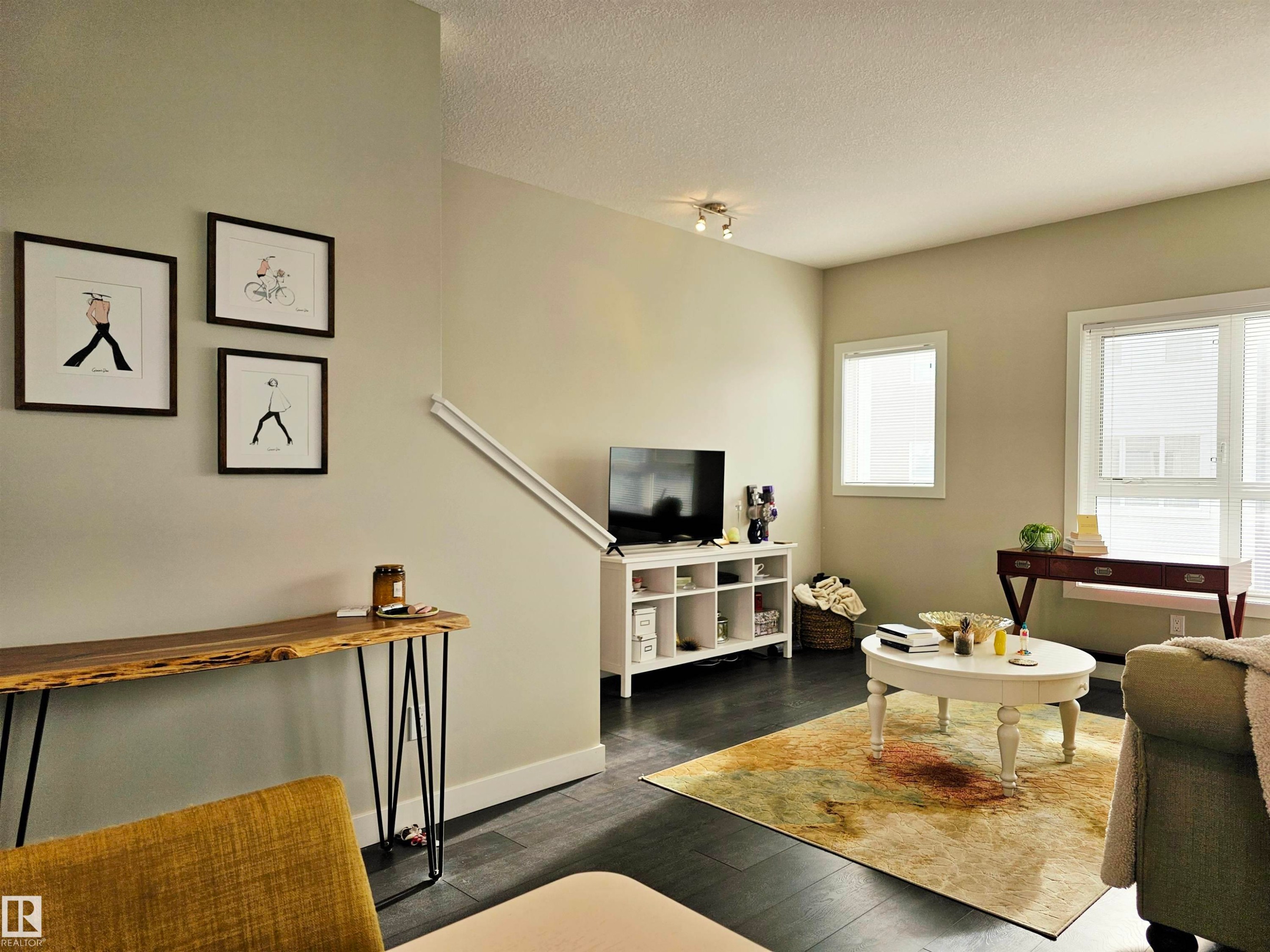 Living area featuring dark wood-type flooring and a textured ceiling - 129 2560 Pegasus Boulevard, Edmonton, AB - Indoor