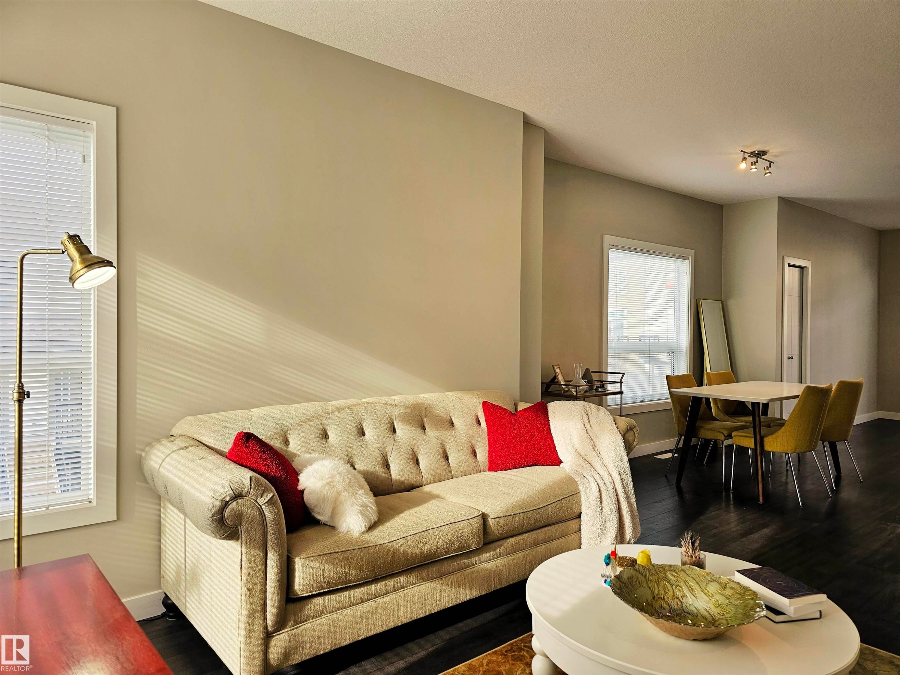Living area with baseboards and wood finished floors - 129 2560 Pegasus Boulevard, Edmonton, AB - Indoor Photo Showing Living Room