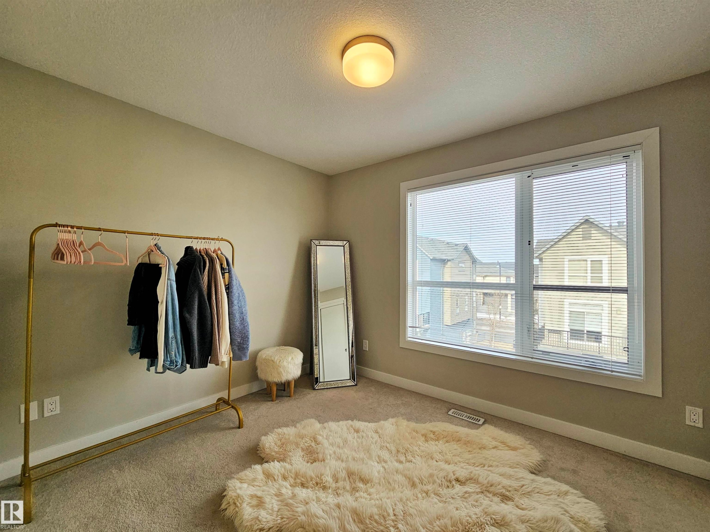 Bedroom with carpet flooring and a textured ceiling - 129 2560 Pegasus Boulevard, Edmonton, AB - Indoor