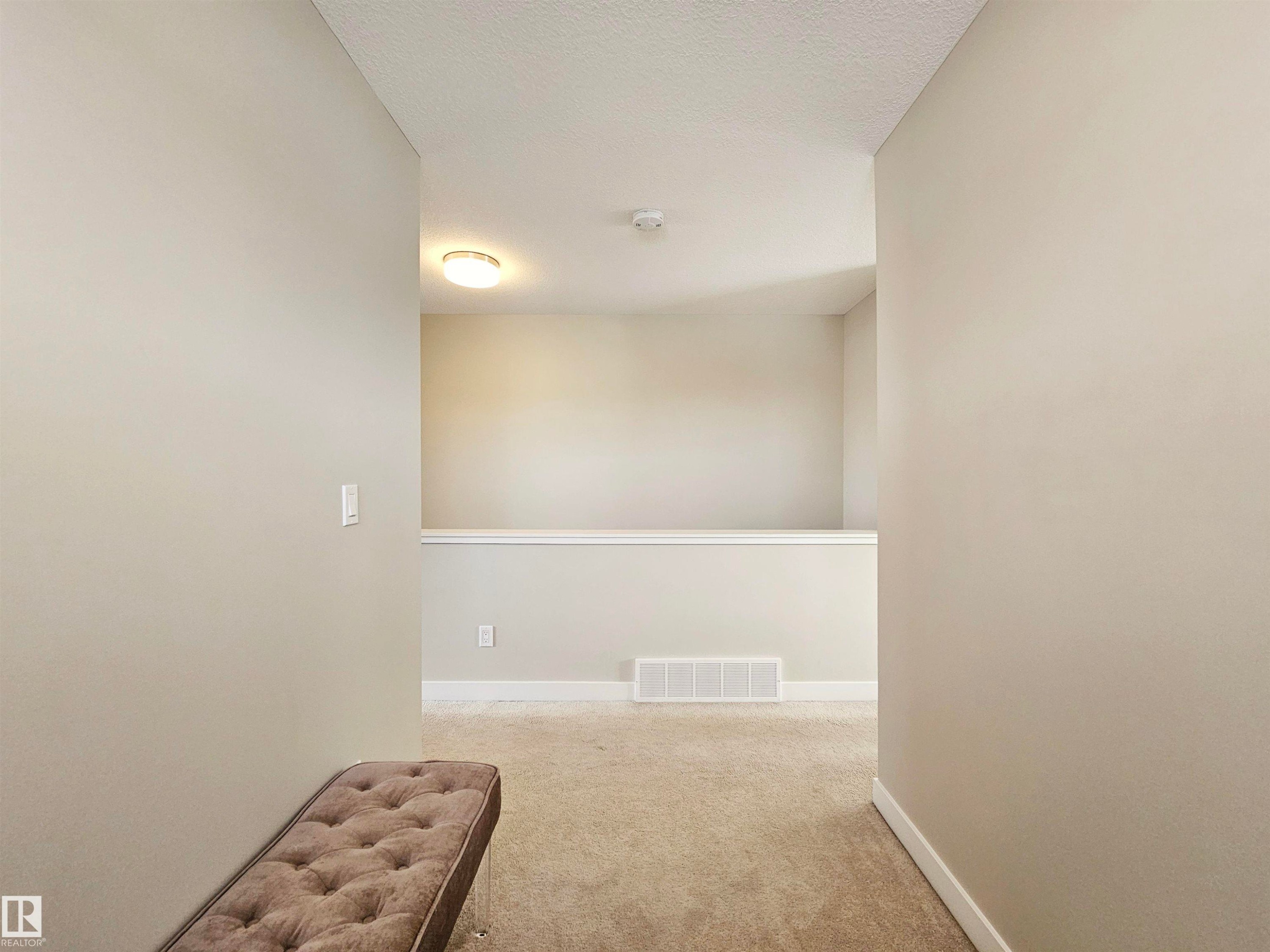 Corridor with light carpet and a textured ceiling - 129 2560 Pegasus Boulevard, Edmonton, AB - Indoor Photo Showing Other Room