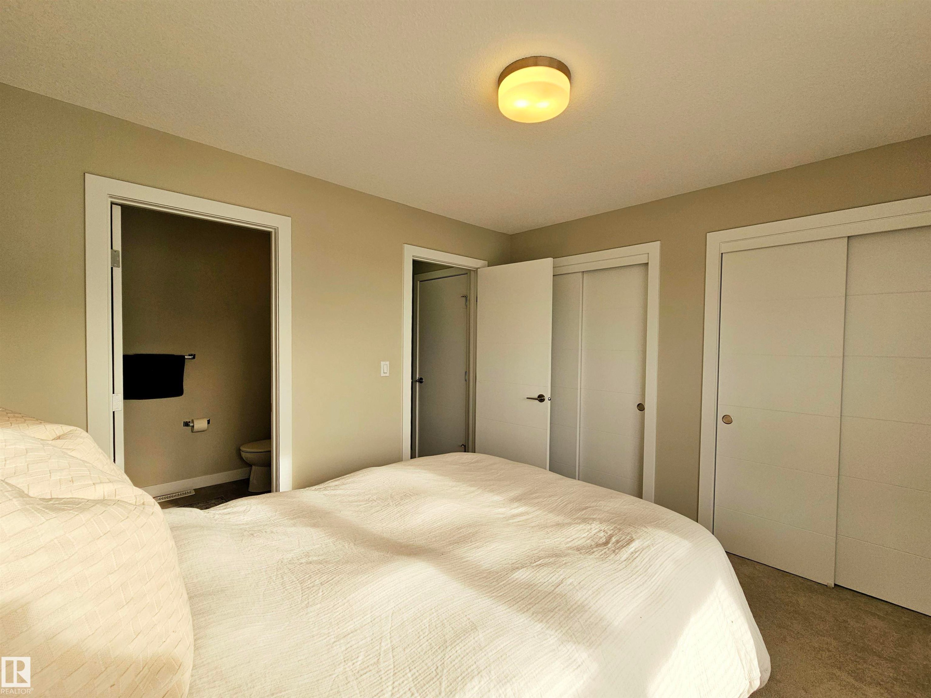 Bedroom featuring multiple closets, carpet, and ensuite bathroom - 129 2560 Pegasus Boulevard, Edmonton, AB - Indoor Photo Showing Bedroom