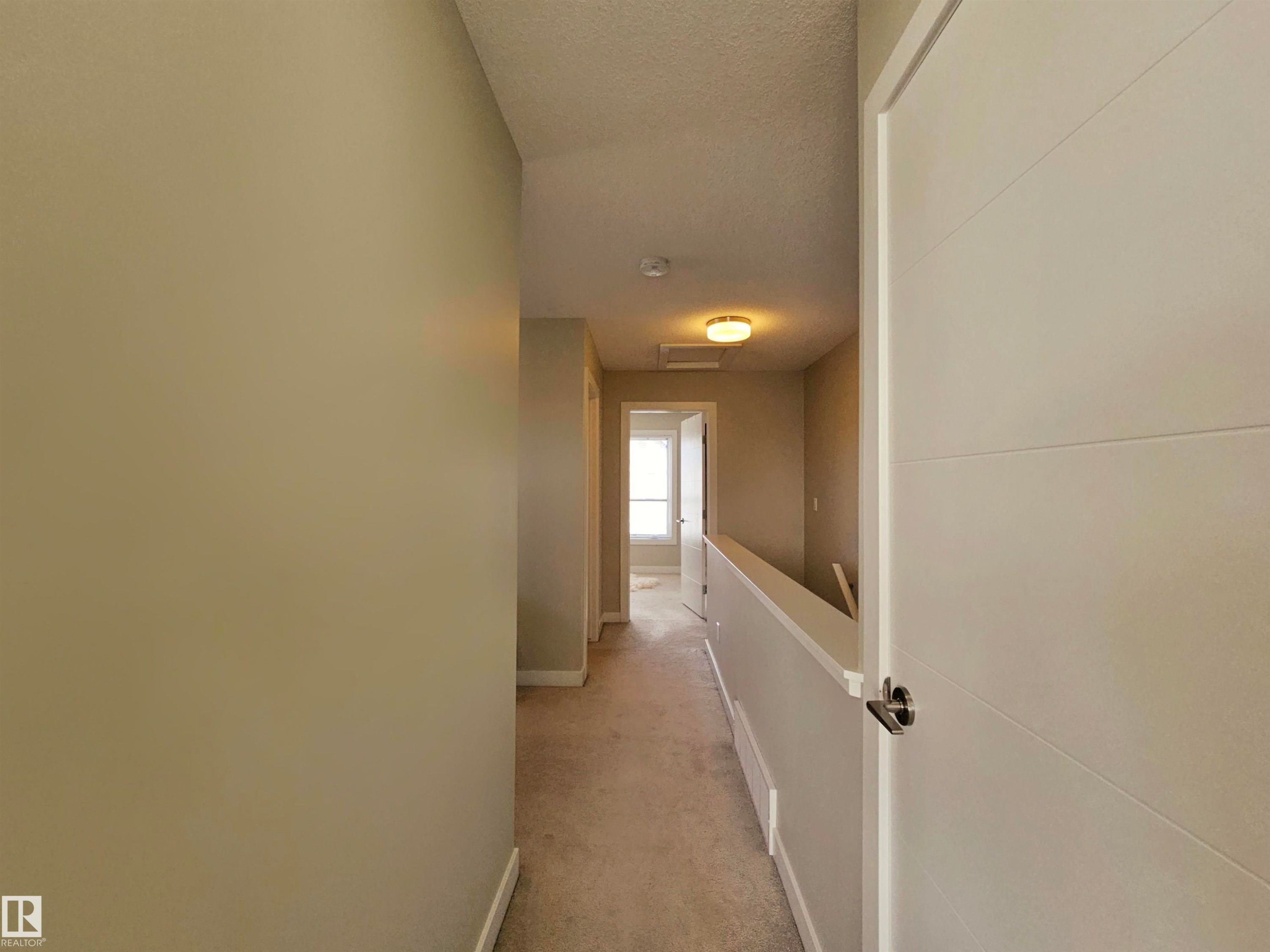 Hallway with light carpet and a textured ceiling - 129 2560 Pegasus Boulevard, Edmonton, AB - Indoor Photo Showing Other Room