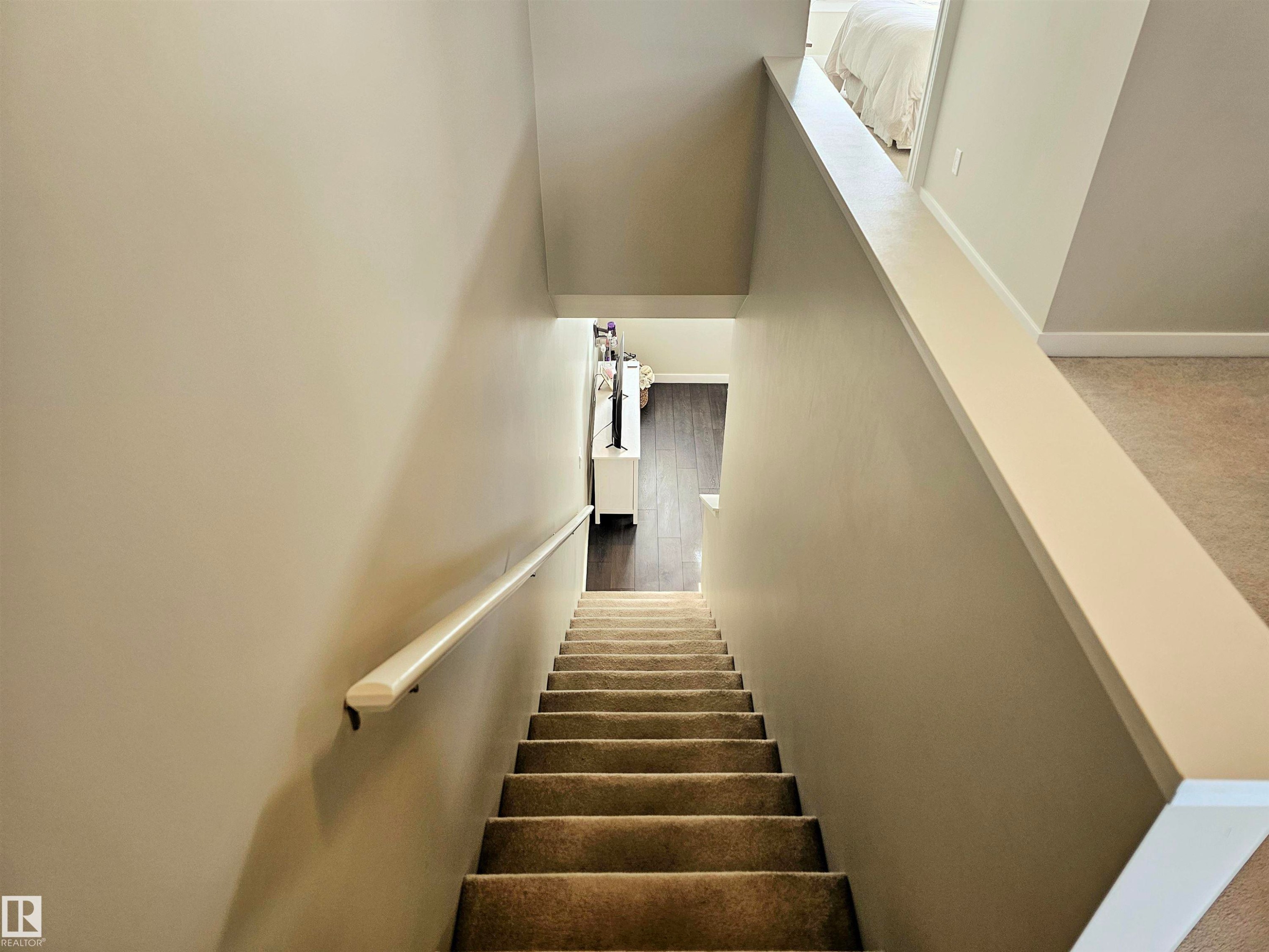 Stairs featuring baseboards and wood finished floors - 129 2560 Pegasus Boulevard, Edmonton, AB - Indoor Photo Showing Other Room