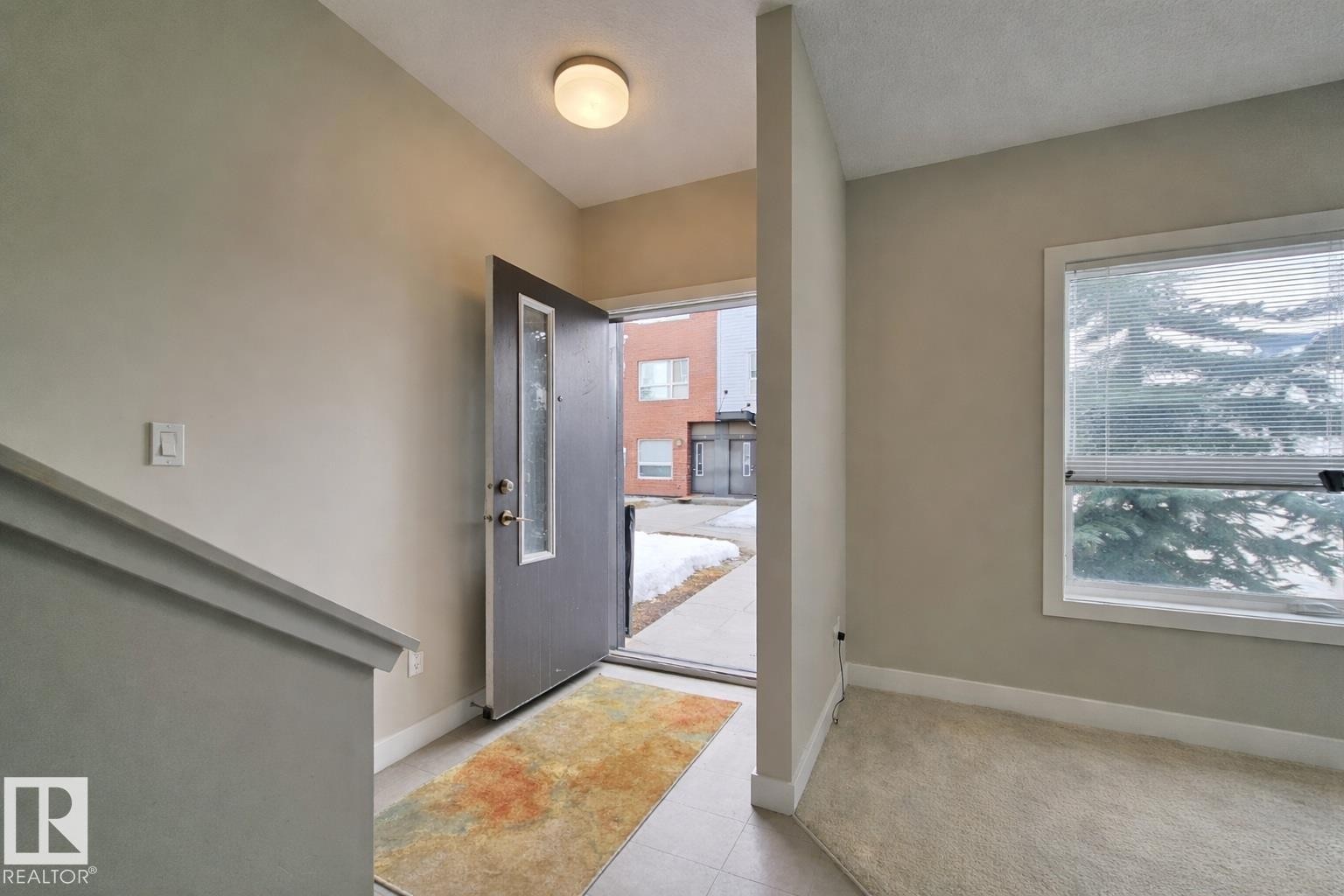 Foyer entrance with baseboards and light tile patterned flooring - 129 2560 Pegasus Boulevard, Edmonton, AB - Indoor Photo Showing Other Room