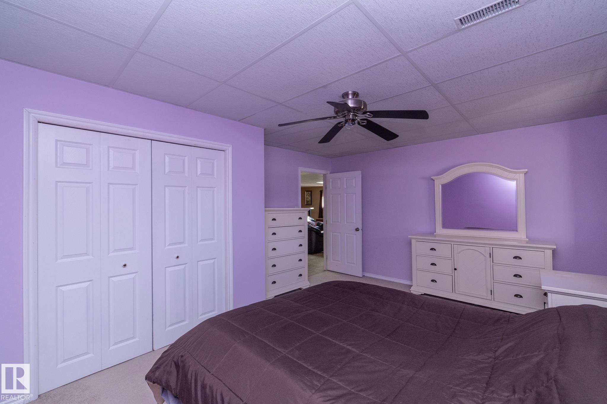 1 of 2 large bedrooms downstairs. Plenty of clost space! Window is above grade & allows afternoon sunshine--West facing--to bring in additional light. More than adequate space, no matter what age. - 57524 Range Road 270, Rural Westlock County, AB - Indoor Photo Showing Bedroom