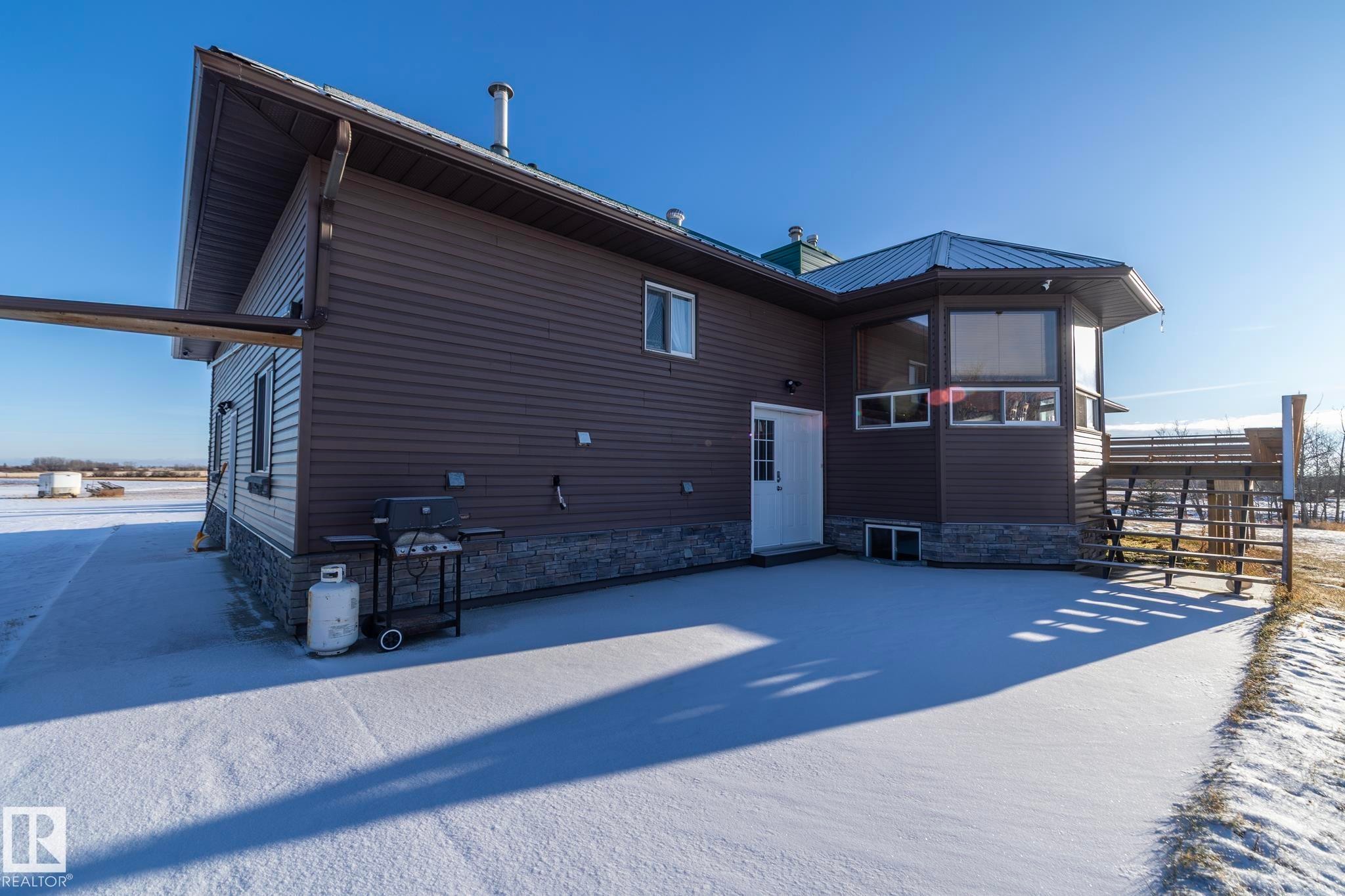Concrete patio, for those summer gatherings for BBQ's and other celebrations---plenty of space! Stairs up to the deck & the back entrance to the house for easy access to the kitchen (and bathrooms!) - 57524 Range Road 270, Rural Westlock County, AB - Outdoor With Exterior