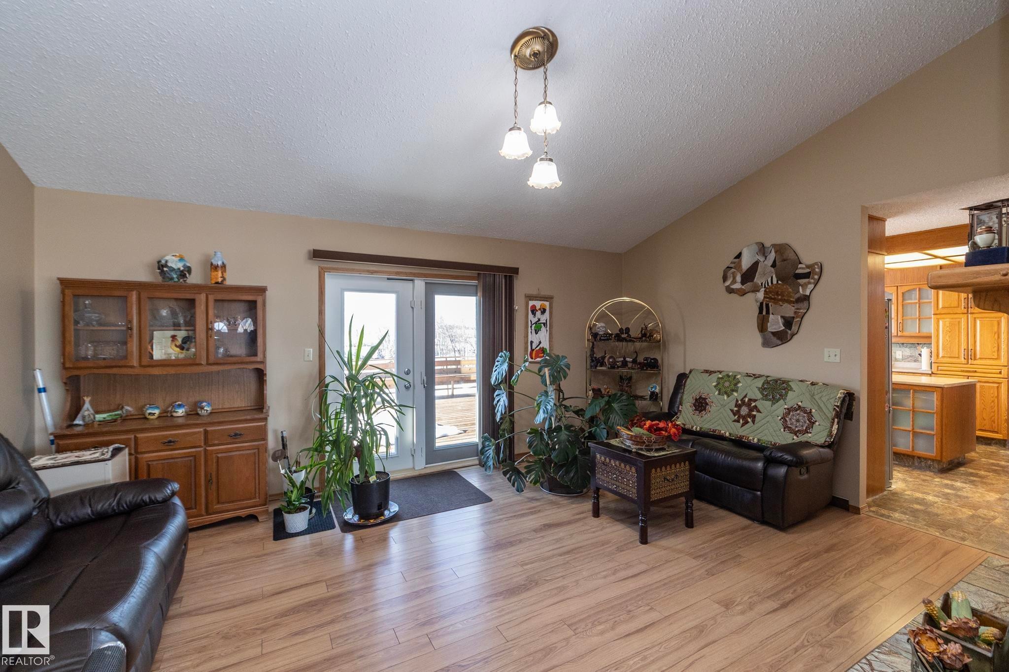 Relaxing and cozy yet open and airy too. This room shares the 2 sided fireplace with the living room and it also has garden doors which lead to the huge West facing deck. This home has plenty of living and entertaining space, inside and out! - 57524 Range Road 270, Rural Westlock County, AB - Indoor Photo Showing Living Room