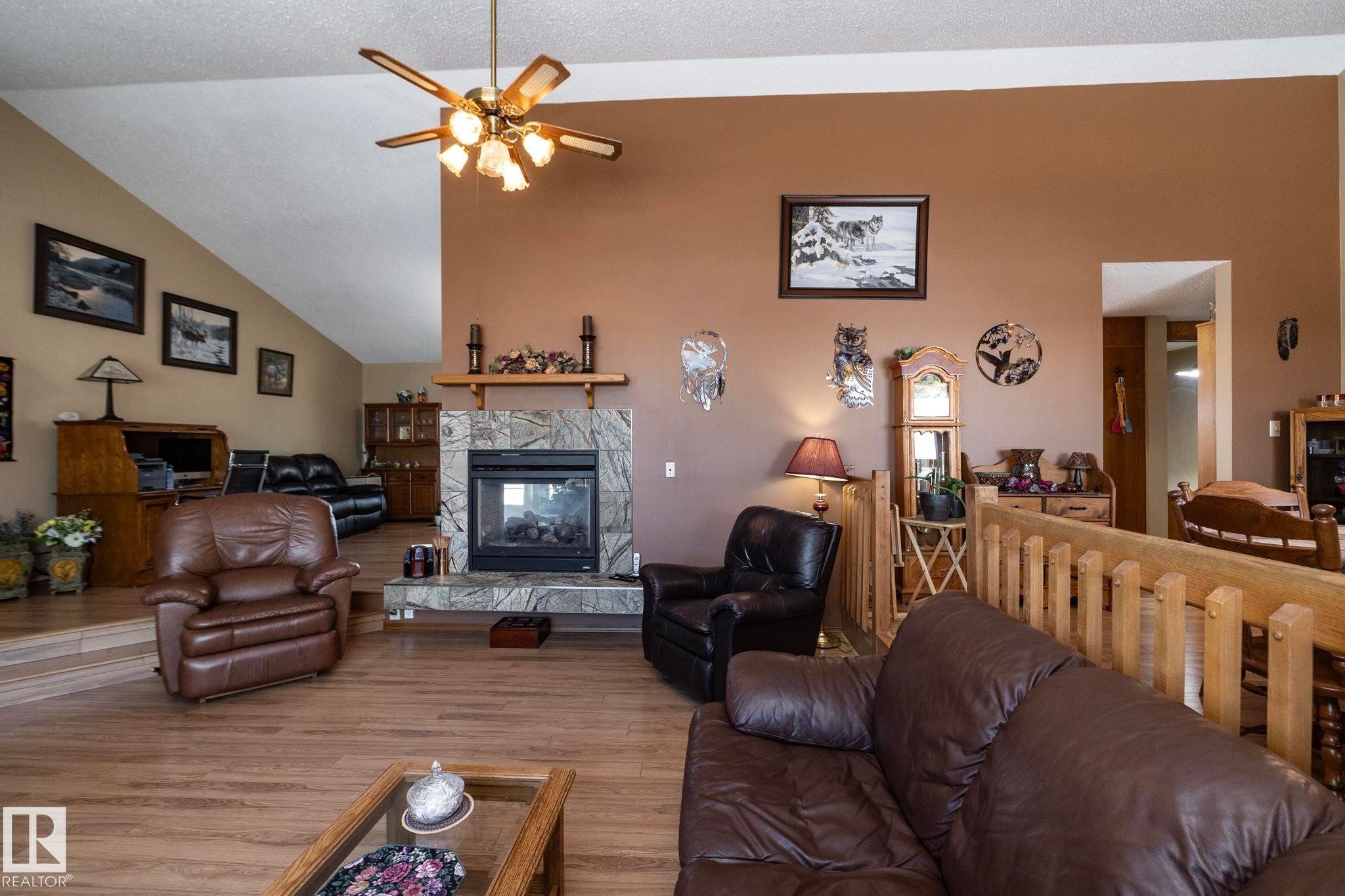 Lots of natural light fills this room and allows for sunrise vistas too! Great spot for conversations, relaxing by the fireplace, there's plenty of seating space for everyone. - 57524 Range Road 270, Rural Westlock County, AB - Indoor Photo Showing Living Room With Fireplace