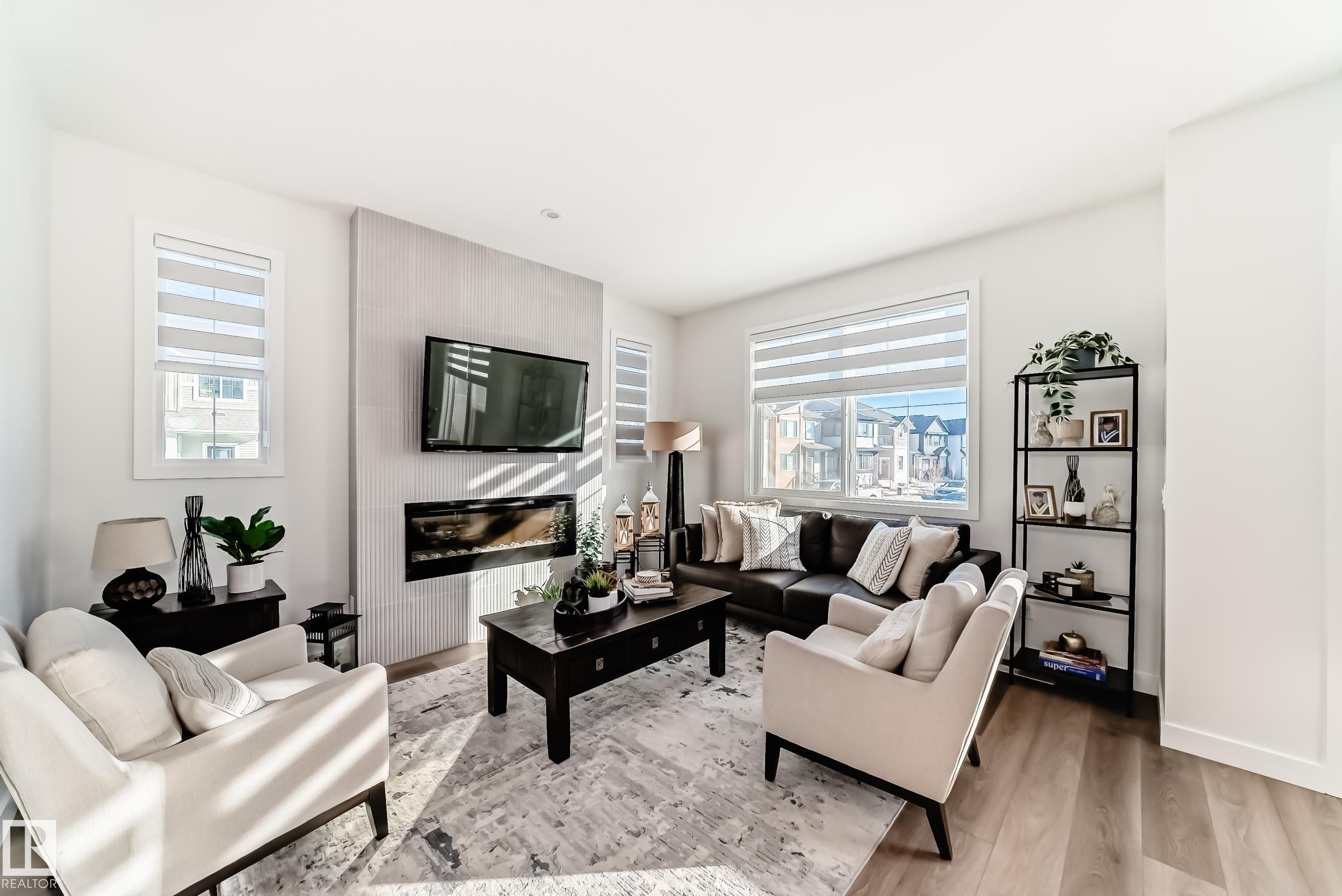 Living area featuring wood finished floors and a large fireplace - 3569 Erlanger Link, Edmonton, AB - Indoor Photo Showing Living Room With Fireplace