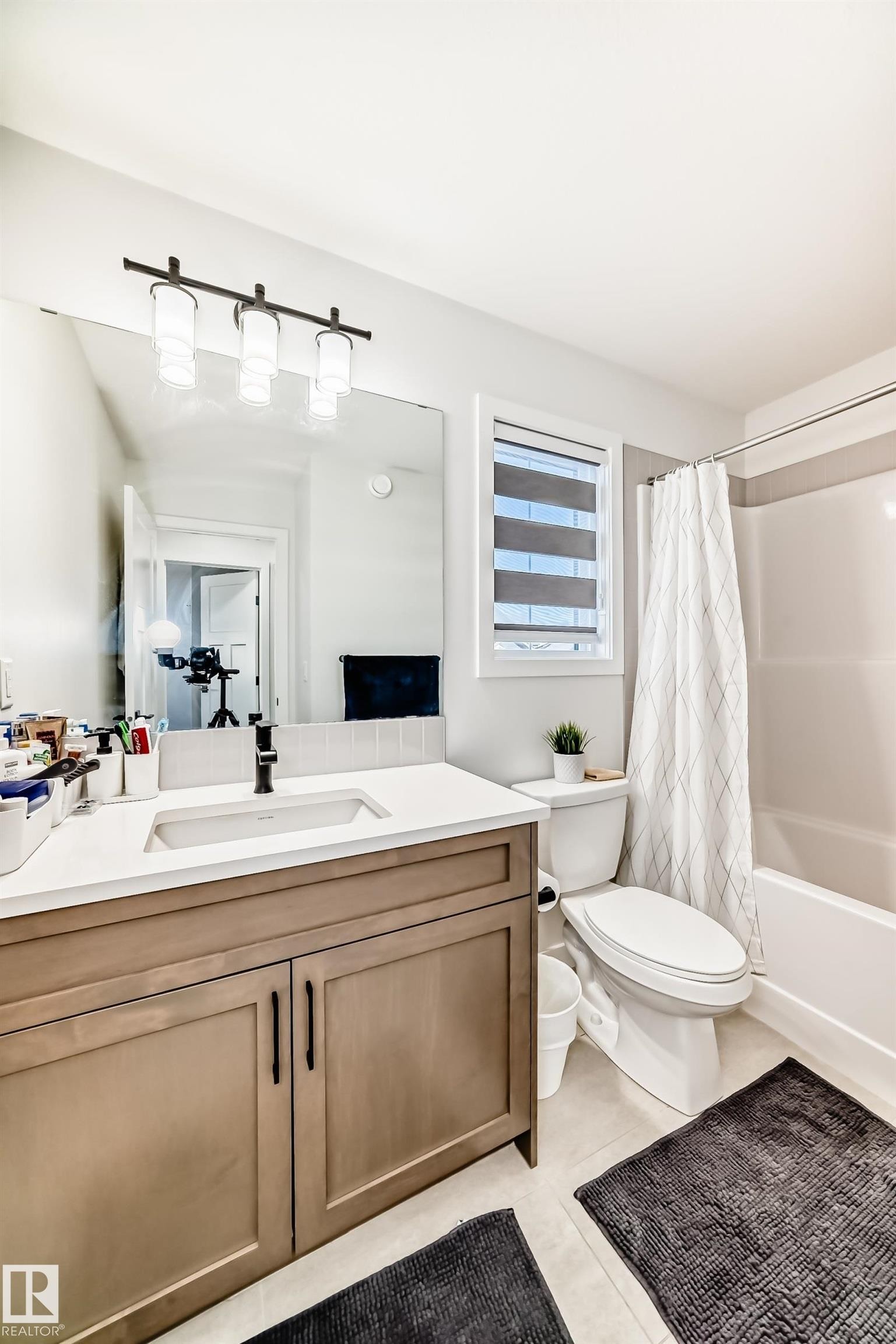 Full bathroom with vanity, shower / bath combo with shower curtain, and light tile patterned floors - 3569 Erlanger Link, Edmonton, AB - Indoor Photo Showing Bathroom