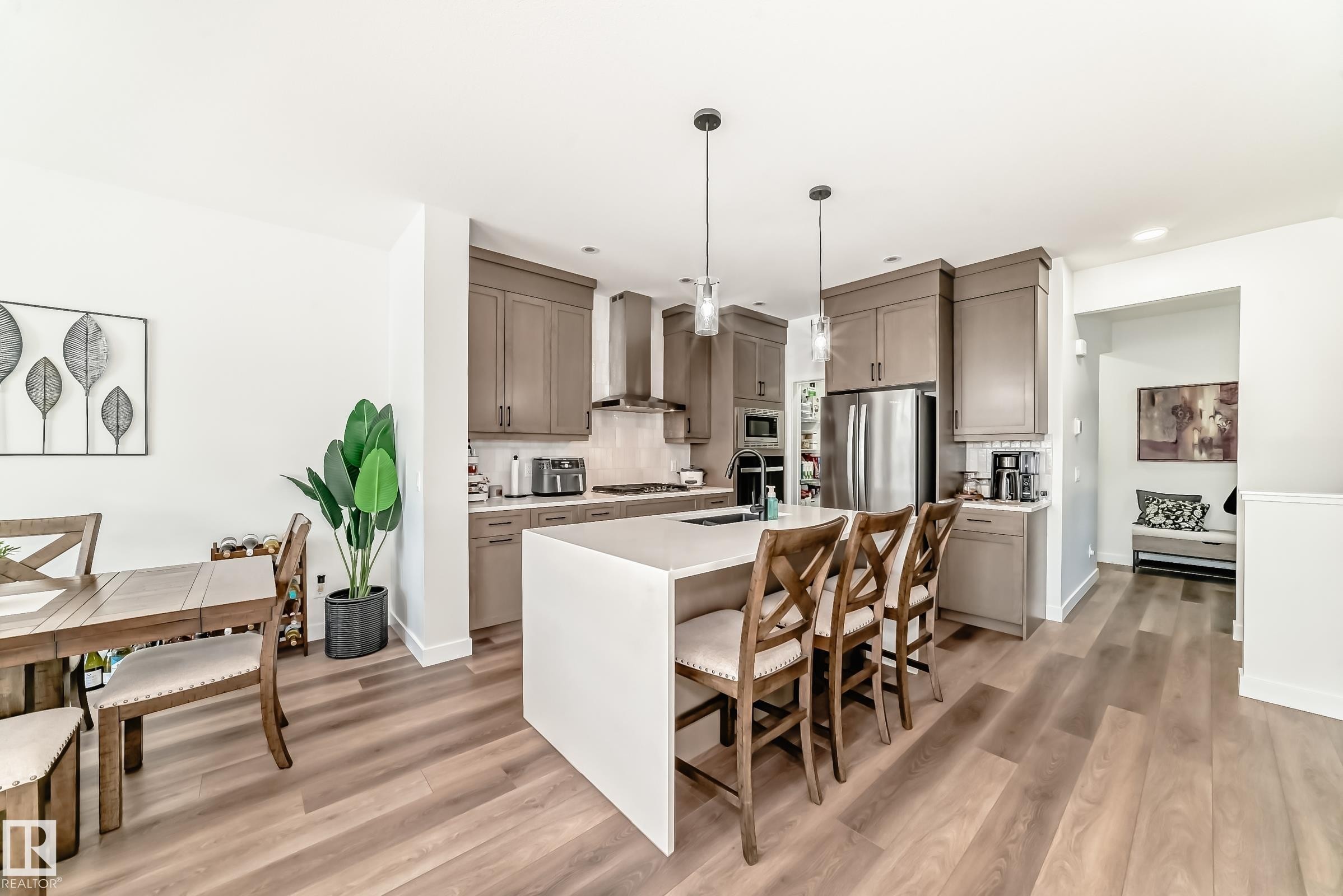 Kitchen with a kitchen breakfast bar, pendant lighting, an island with sink, and light wood-style floors - 3569 Erlanger Link, Edmonton, AB - Indoor