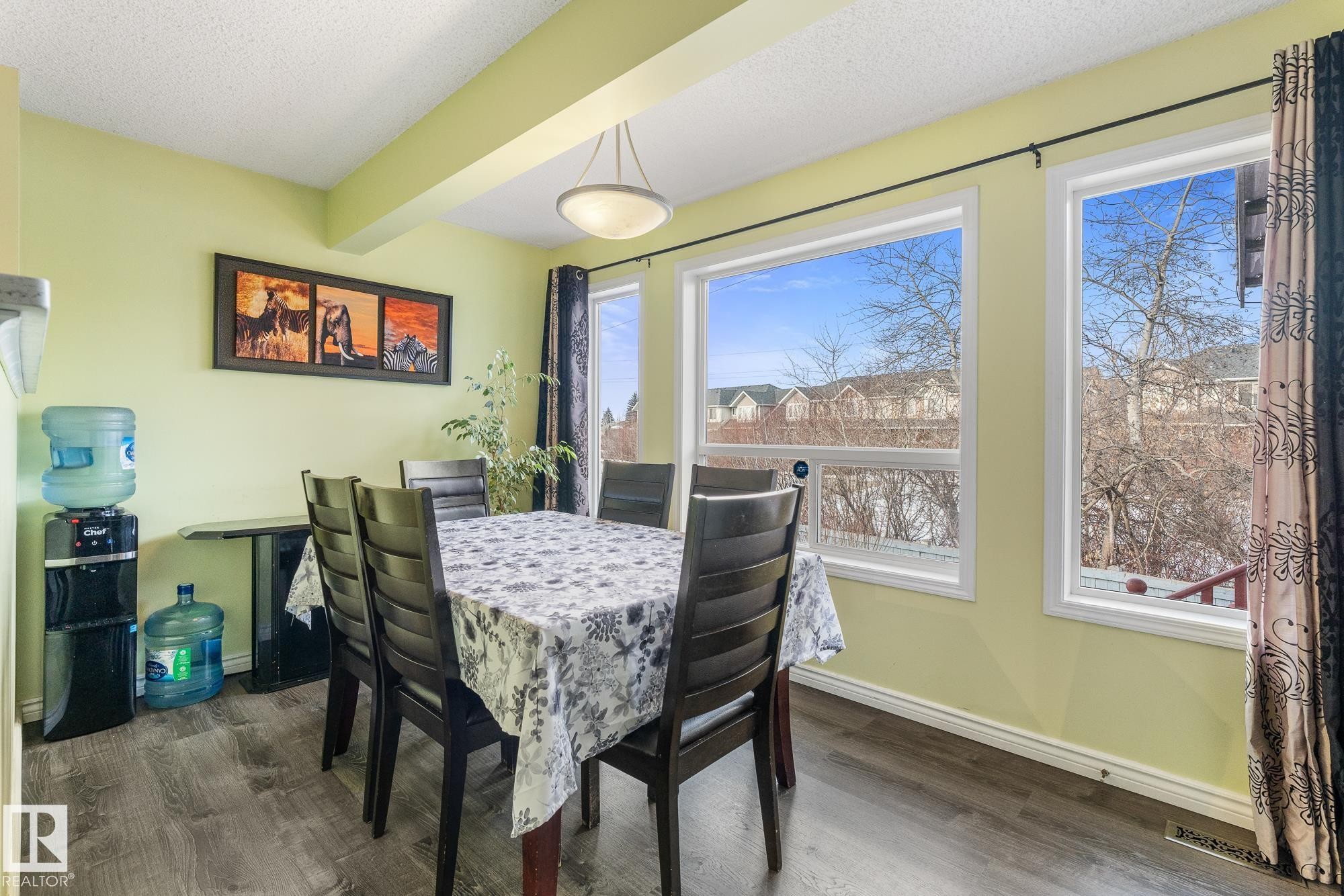 Dining space featuring dark wood-style floors, beam ceiling, and a textured ceiling - 13148 151 Avenue, Edmonton, AB - Indoor Photo Showing Dining Room