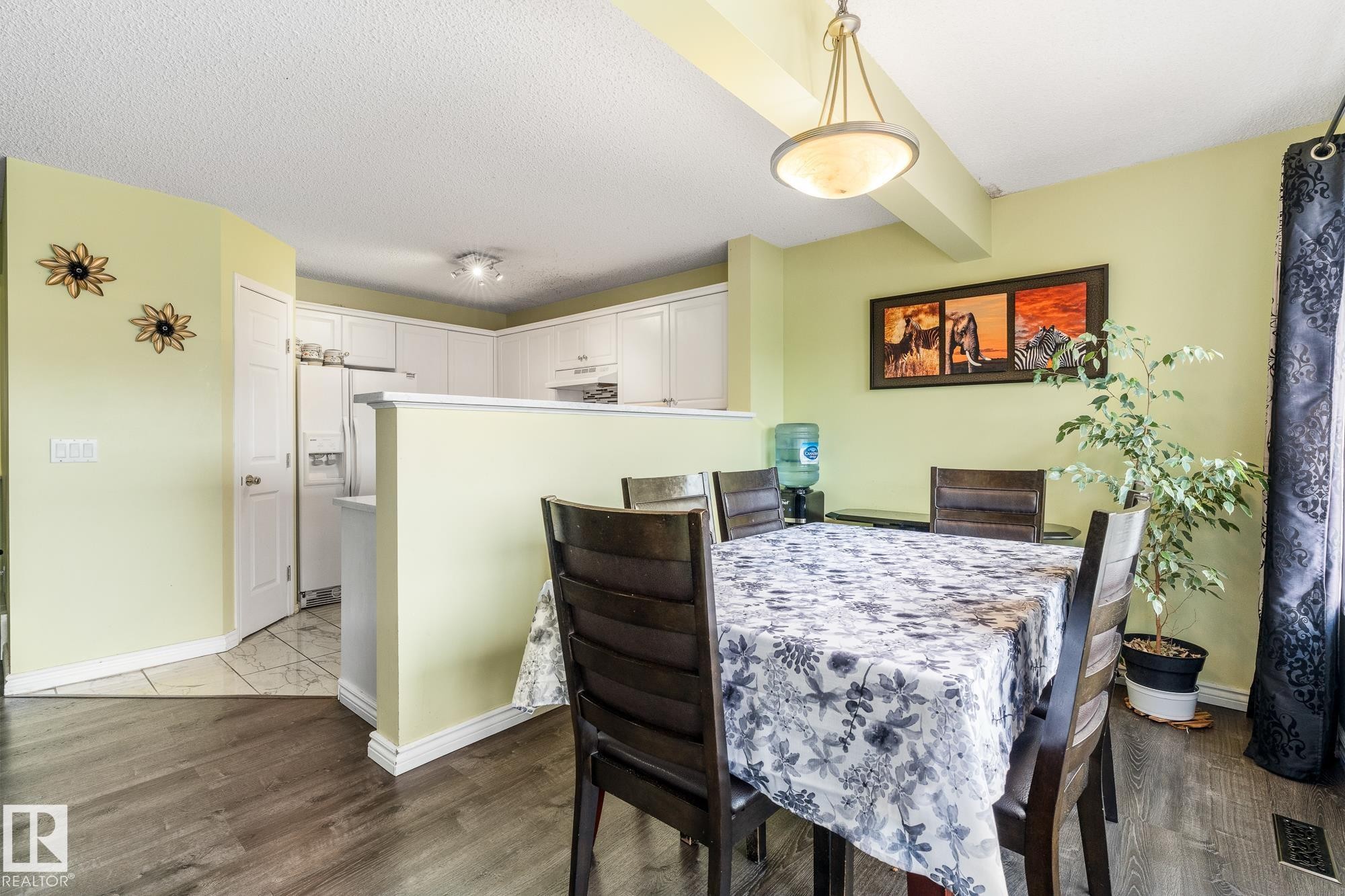 Dining area featuring dark wood-style flooring and a textured ceiling - 13148 151 Avenue, Edmonton, AB - Indoor Photo Showing Dining Room