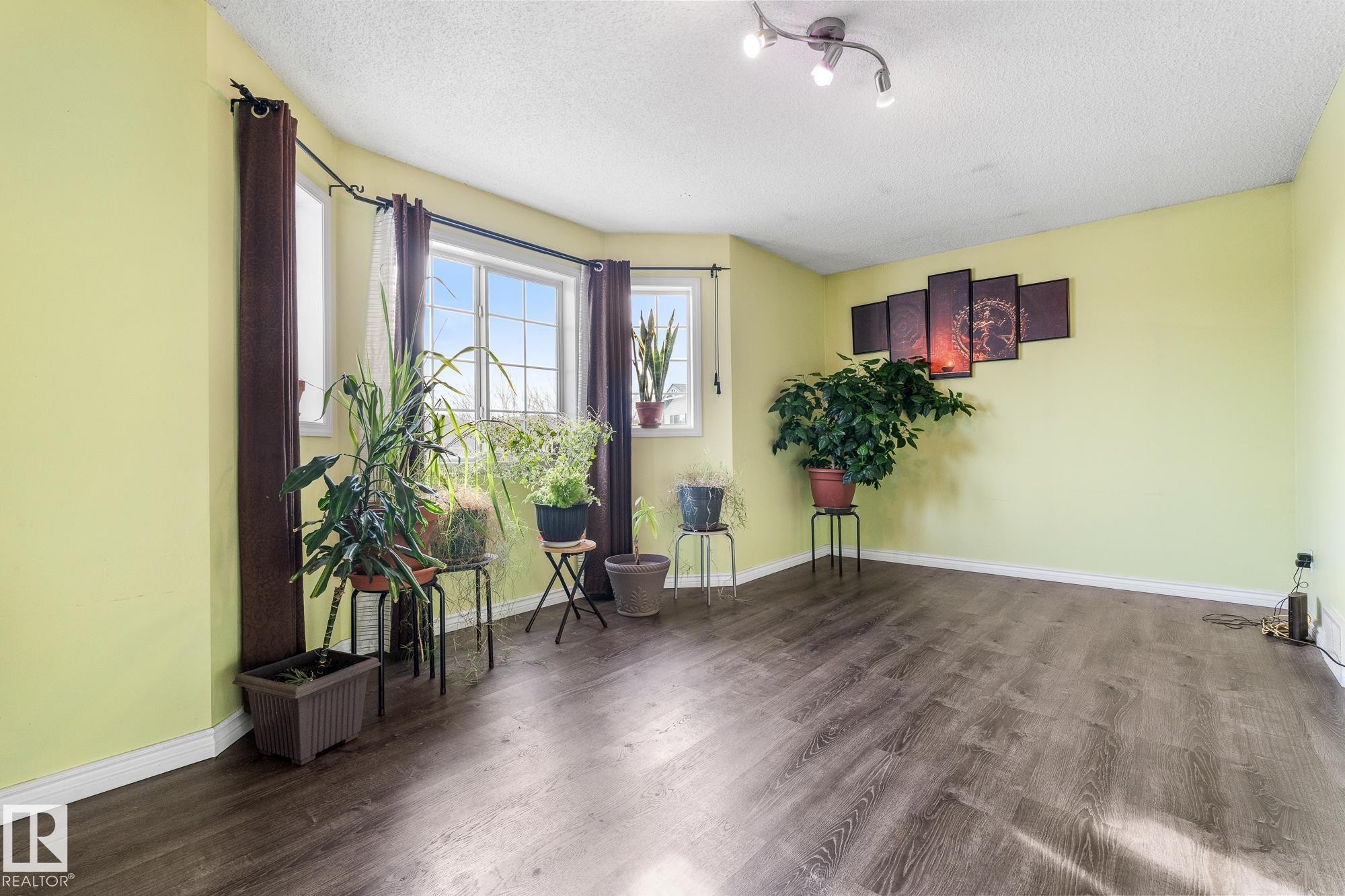 Living area with dark wood-style floors and a textured ceiling - 13148 151 Avenue, Edmonton, AB - Indoor Photo Showing Other Room