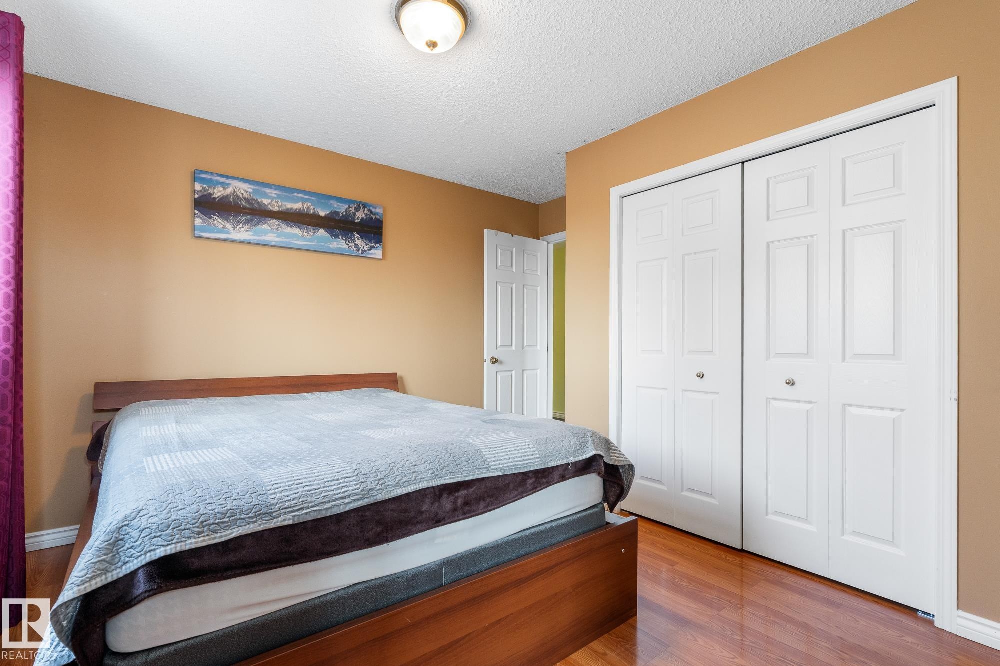Bedroom featuring wood finished floors, a closet, and a textured ceiling - 13148 151 Avenue, Edmonton, AB - Indoor Photo Showing Bedroom