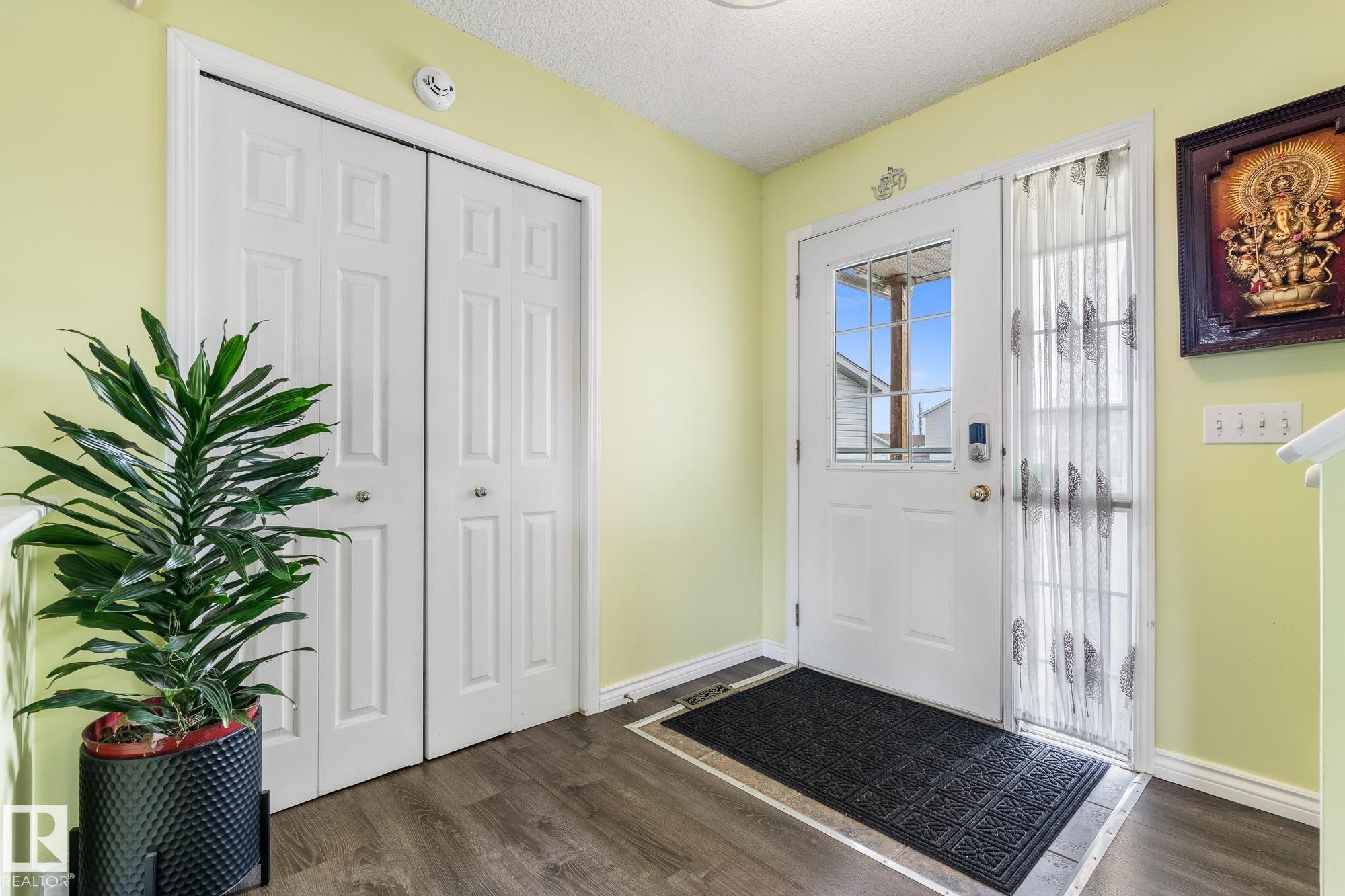 Entrance foyer with dark wood-style floors and a textured ceiling - 13148 151 Avenue, Edmonton, AB - Indoor Photo Showing Other Room