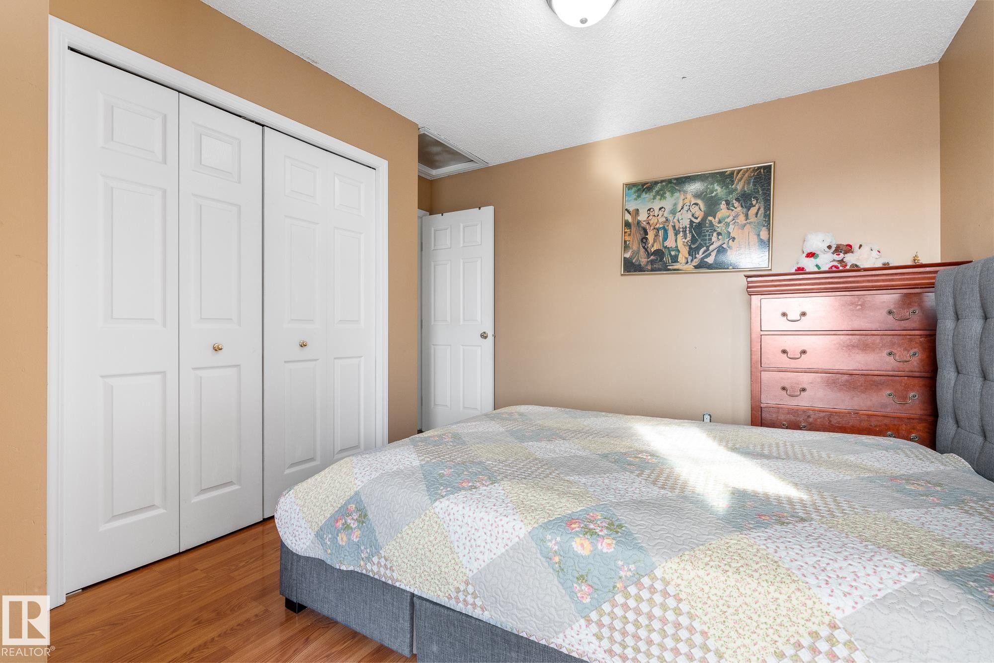 Bedroom featuring wood finished floors, a textured ceiling, and a closet - 13148 151 Avenue, Edmonton, AB - Indoor Photo Showing Bedroom