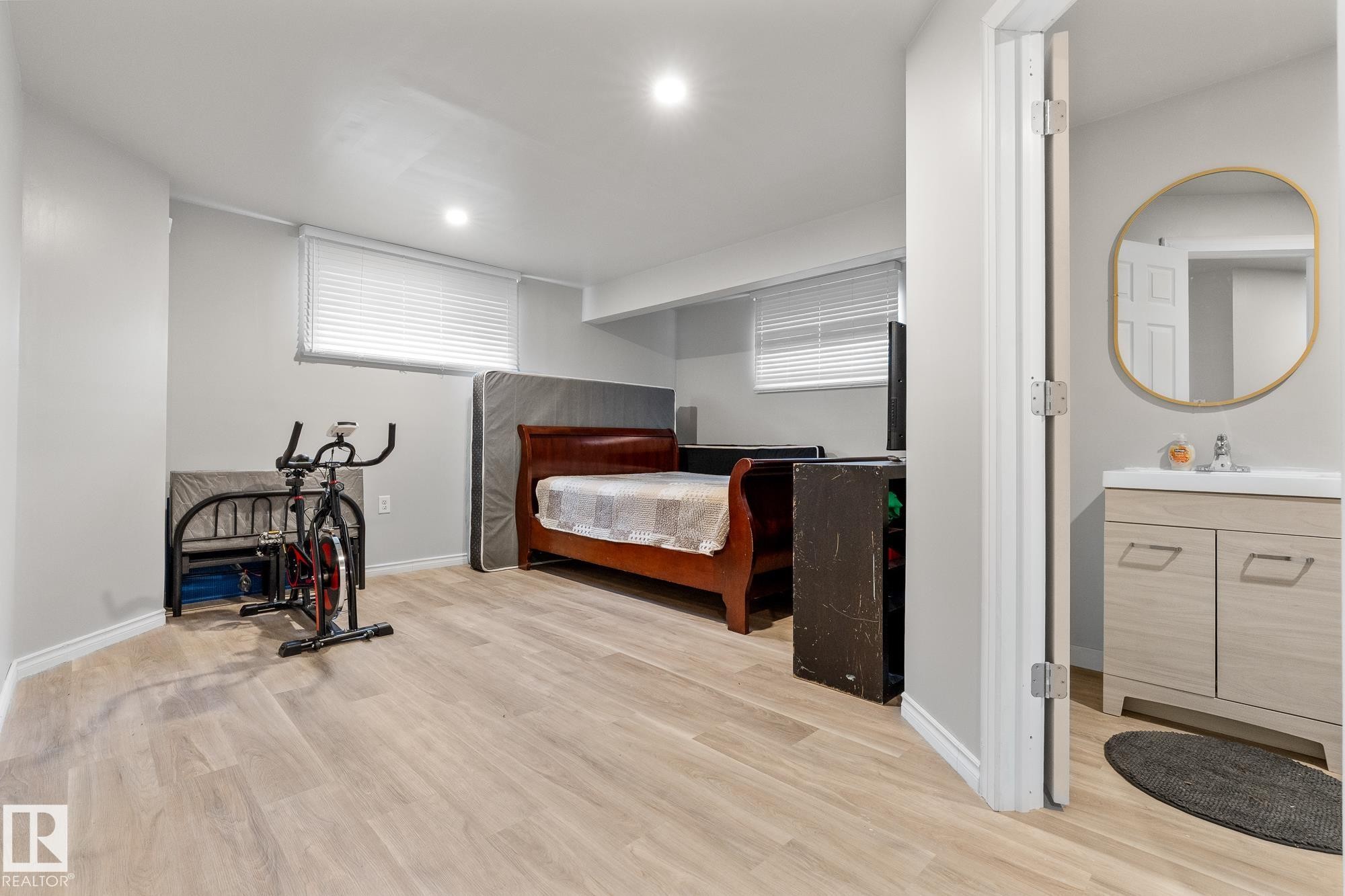 Bedroom with light wood-style floors, recessed lighting, and ensuite bathroom - 13148 151 Avenue, Edmonton, AB - Indoor