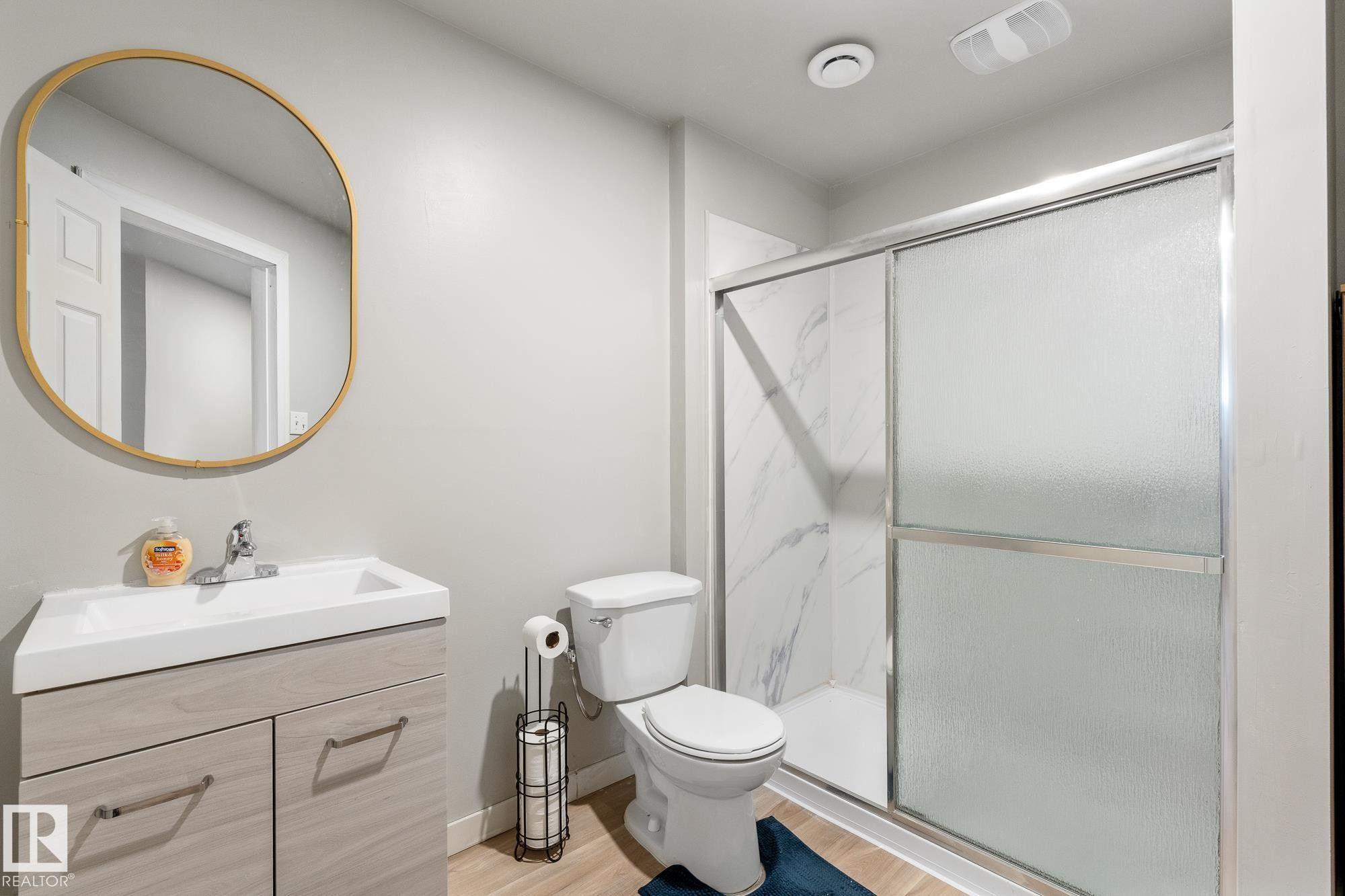 Full bath with vanity, a marble finish shower, and light wood-style flooring - 13148 151 Avenue, Edmonton, AB - Indoor Photo Showing Bathroom