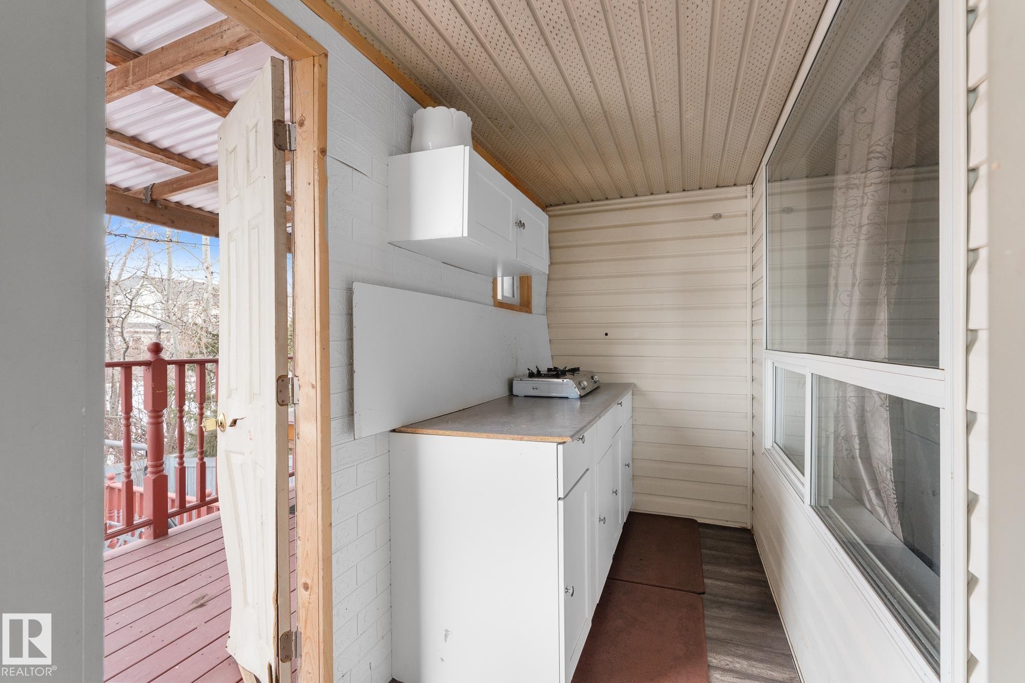 Kitchen featuring white cabinetry, light countertops, and wood finished floors - 13148 151 Avenue, Edmonton, AB - With Exterior
