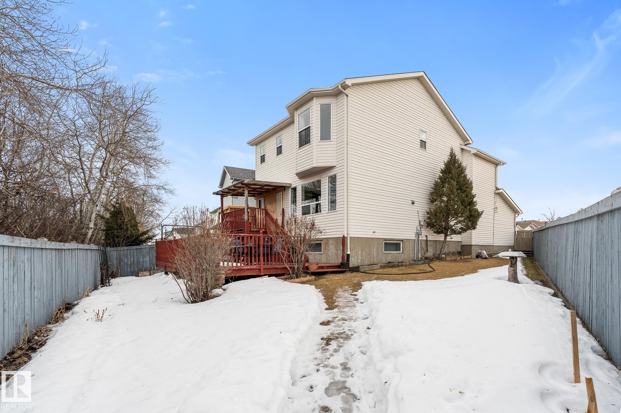 Snow covered property featuring a fenced backyard and a deck - 13148 151 Avenue, Edmonton, AB - Outdoor