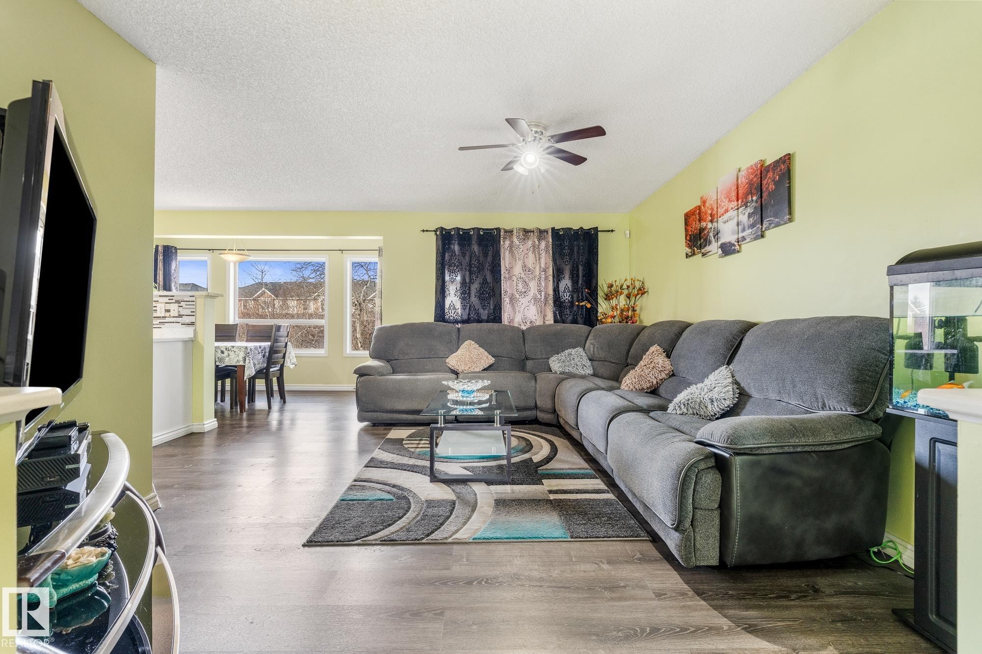 Living room with wood finished floors, a textured ceiling, and ceiling fan - 13148 151 Avenue, Edmonton, AB - Indoor Photo Showing Living Room