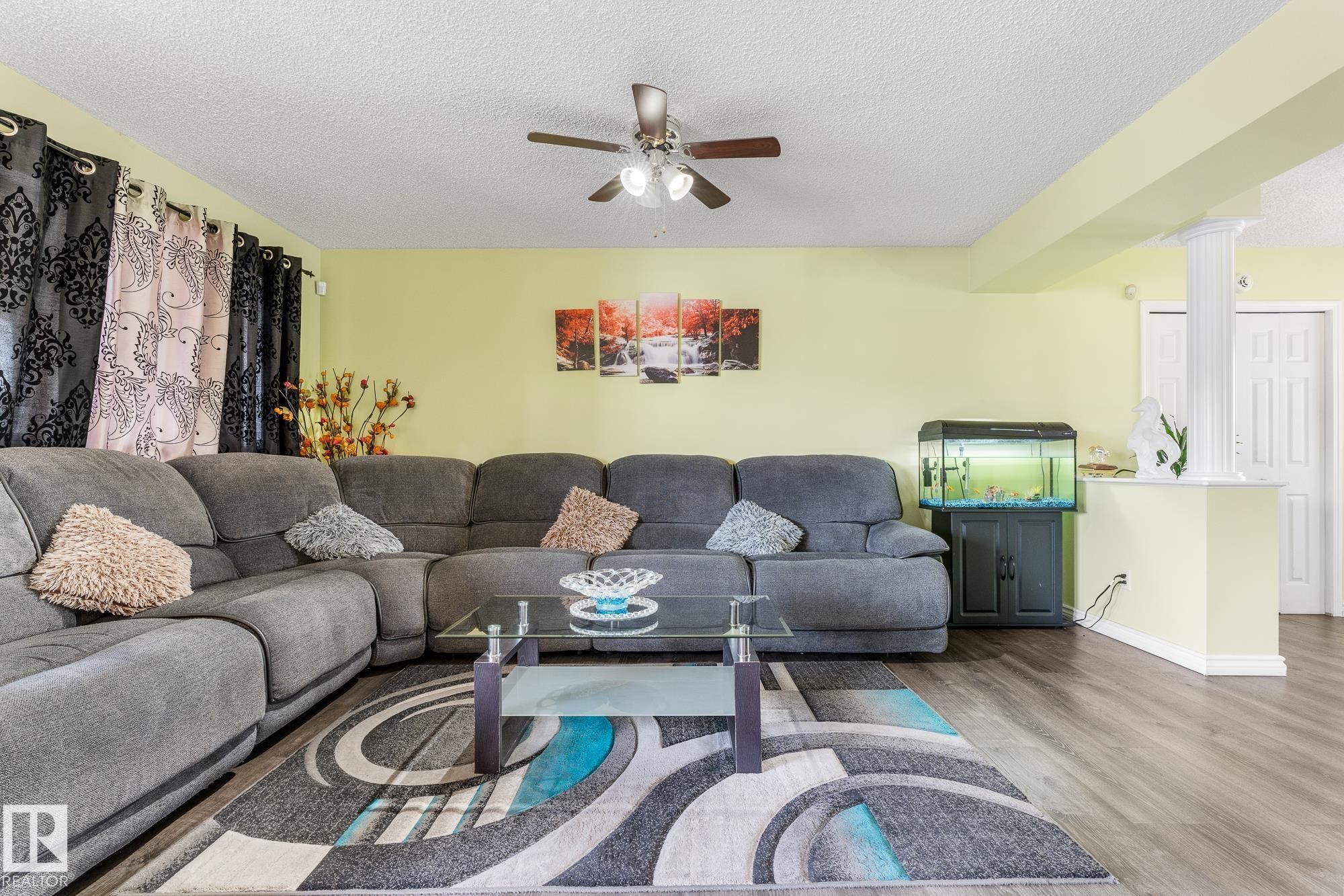 Living area featuring wood finished floors, ceiling fan, and a textured ceiling - 13148 151 Avenue, Edmonton, AB - Indoor Photo Showing Living Room