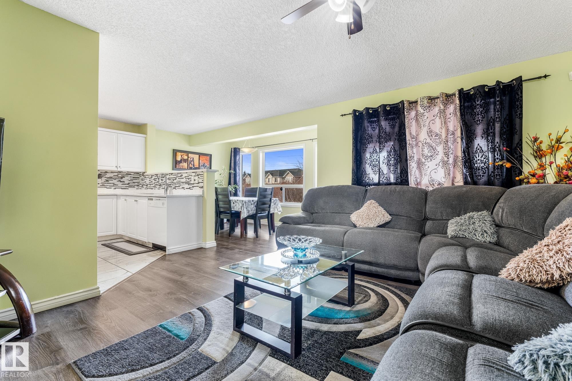 Living room featuring light wood-style floors, a textured ceiling, and ceiling fan - 13148 151 Avenue, Edmonton, AB - Indoor Photo Showing Living Room
